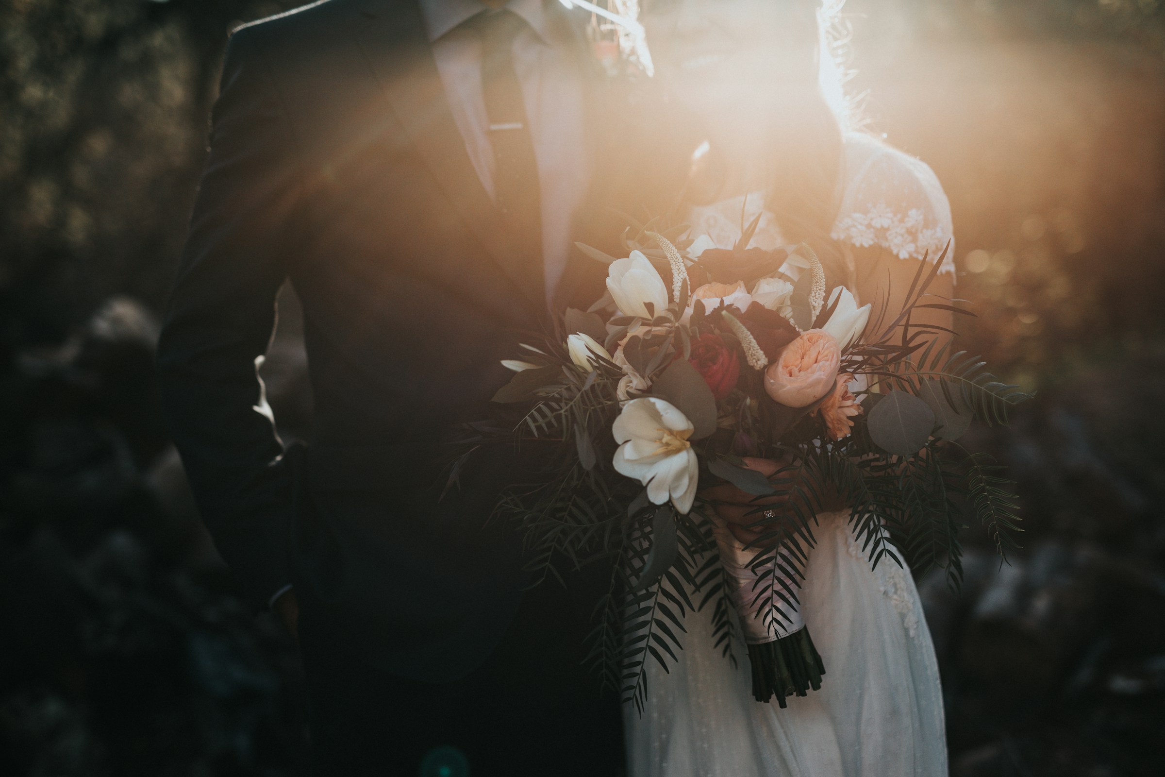 Braut und Bräutigam posieren bei Sonnenuntergang | Quelle: Unsplash