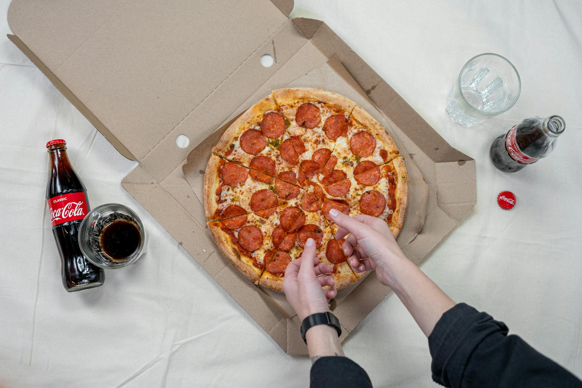 Eine Person, die ein Stück Pizza isst | Quelle: Pexels