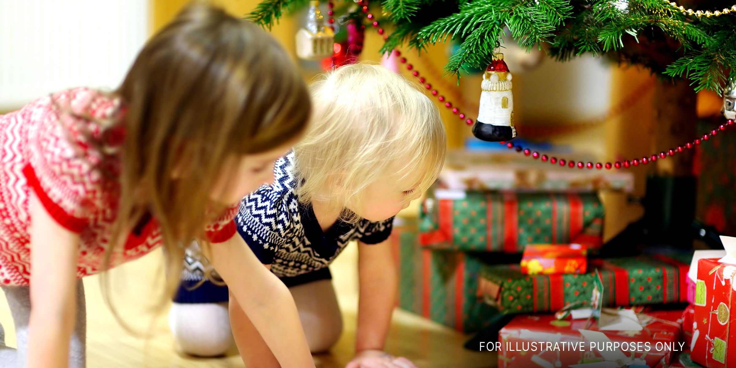 Kinder betrachten die Geschenke unter dem Weihnachtsbaum | Quelle: Shutterstock