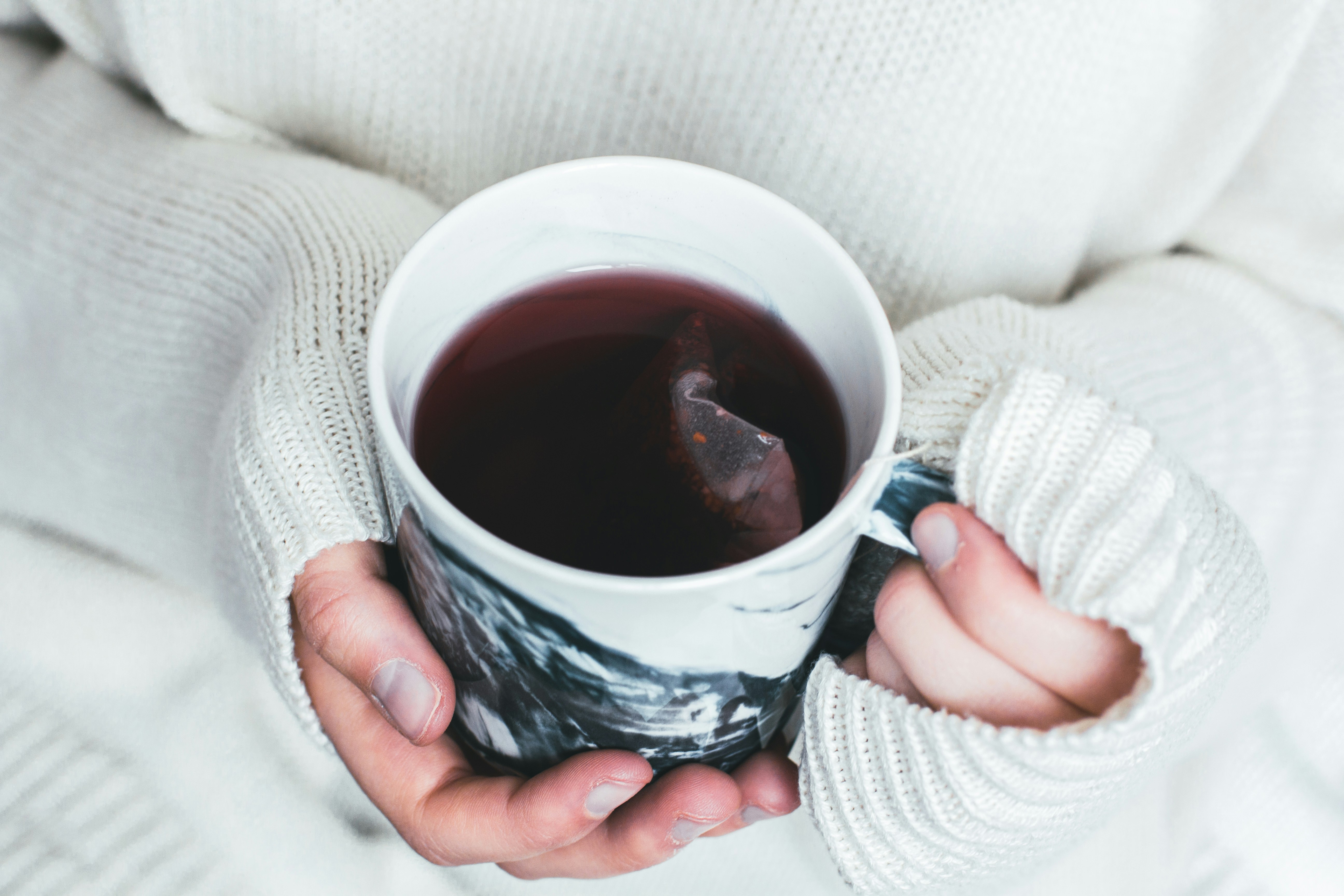 Eine Person mit einer Tasse Tee in der Hand | Quelle: Unsplash