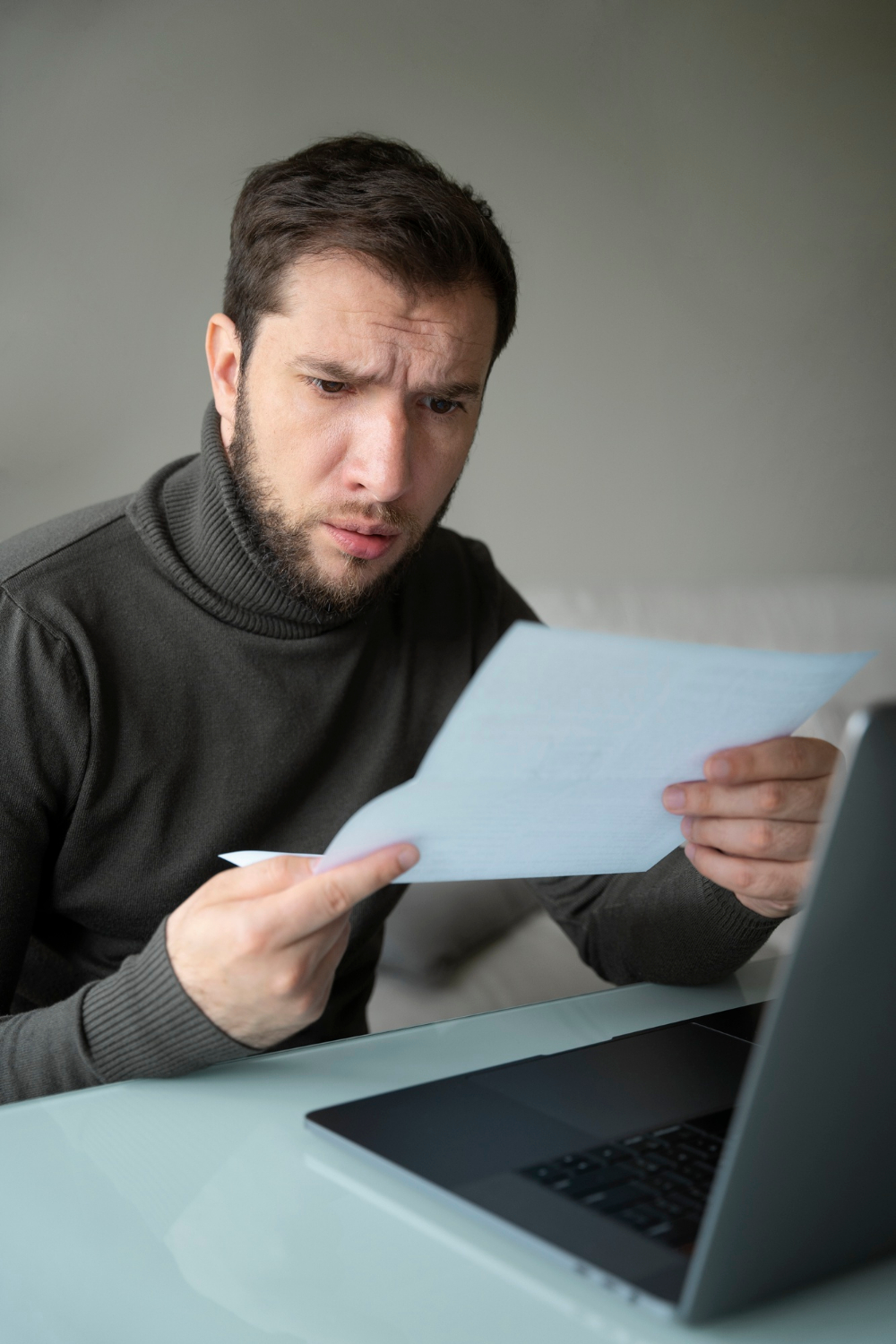 Ein fassungsloser Mann schaut auf ein Blatt Papier | Quelle: Freepik