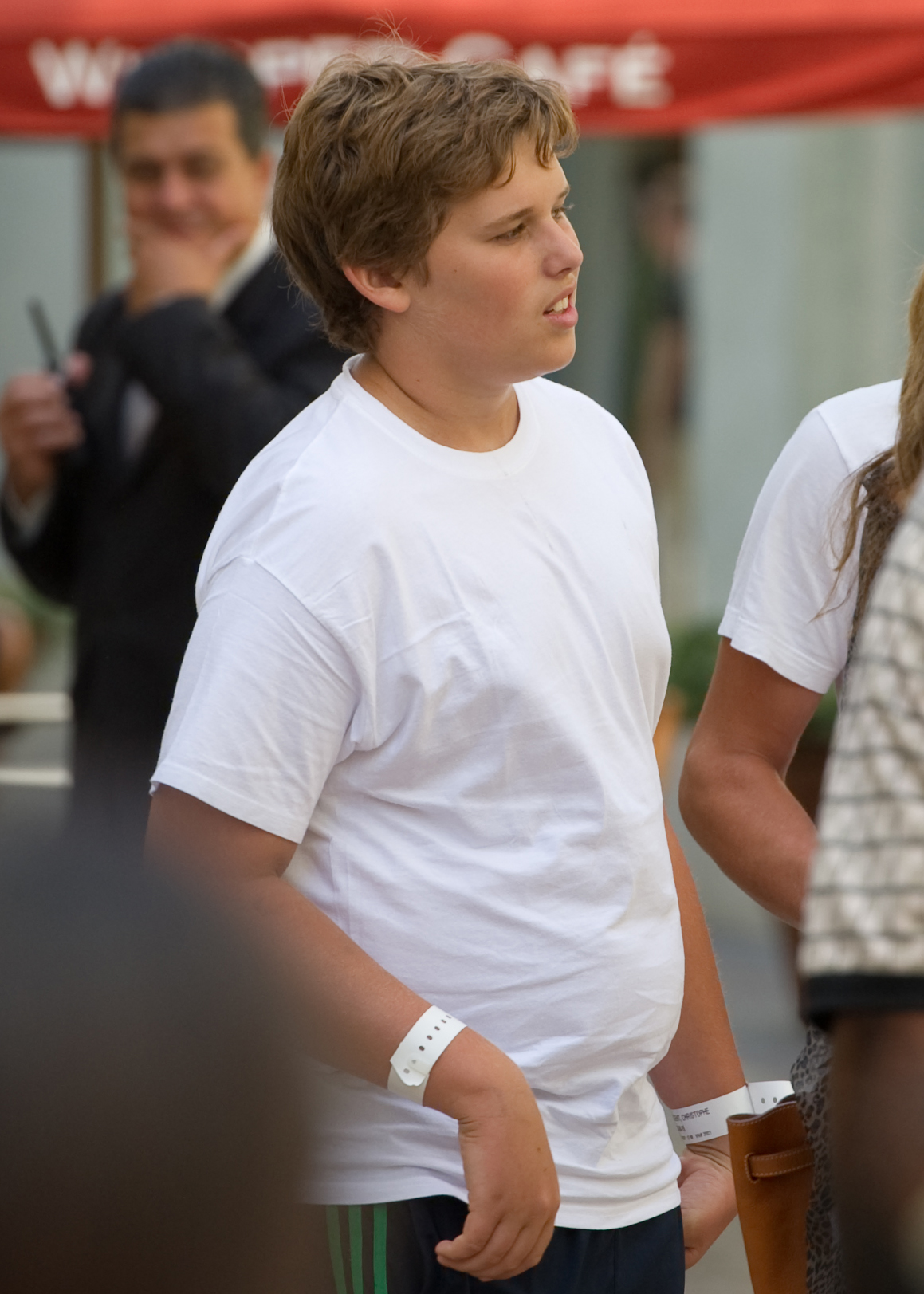 Christopher Schwarzenegger wird am 27. Juli 2011 im The Grove in Los Angeles gesehen. Er trägt ein einfaches weißes T-Shirt und eine dunkle Sporthose. Er sieht aus wie ein Teenager und steht in einer entspannten Atmosphäre zwischen anderen.