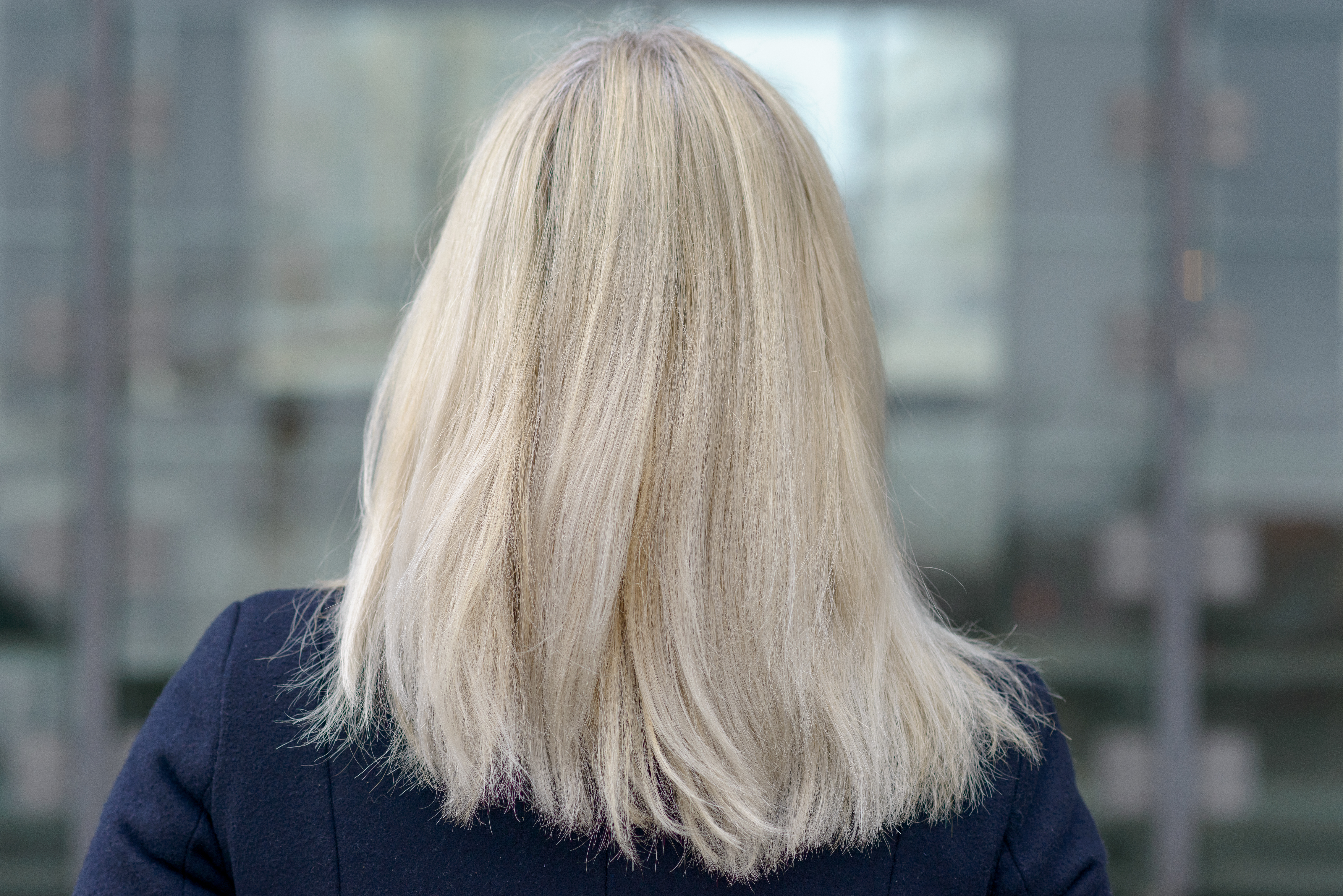 Rückansicht einer Frau mit schulterlangem blondem Haar | Quelle: Shutterstock