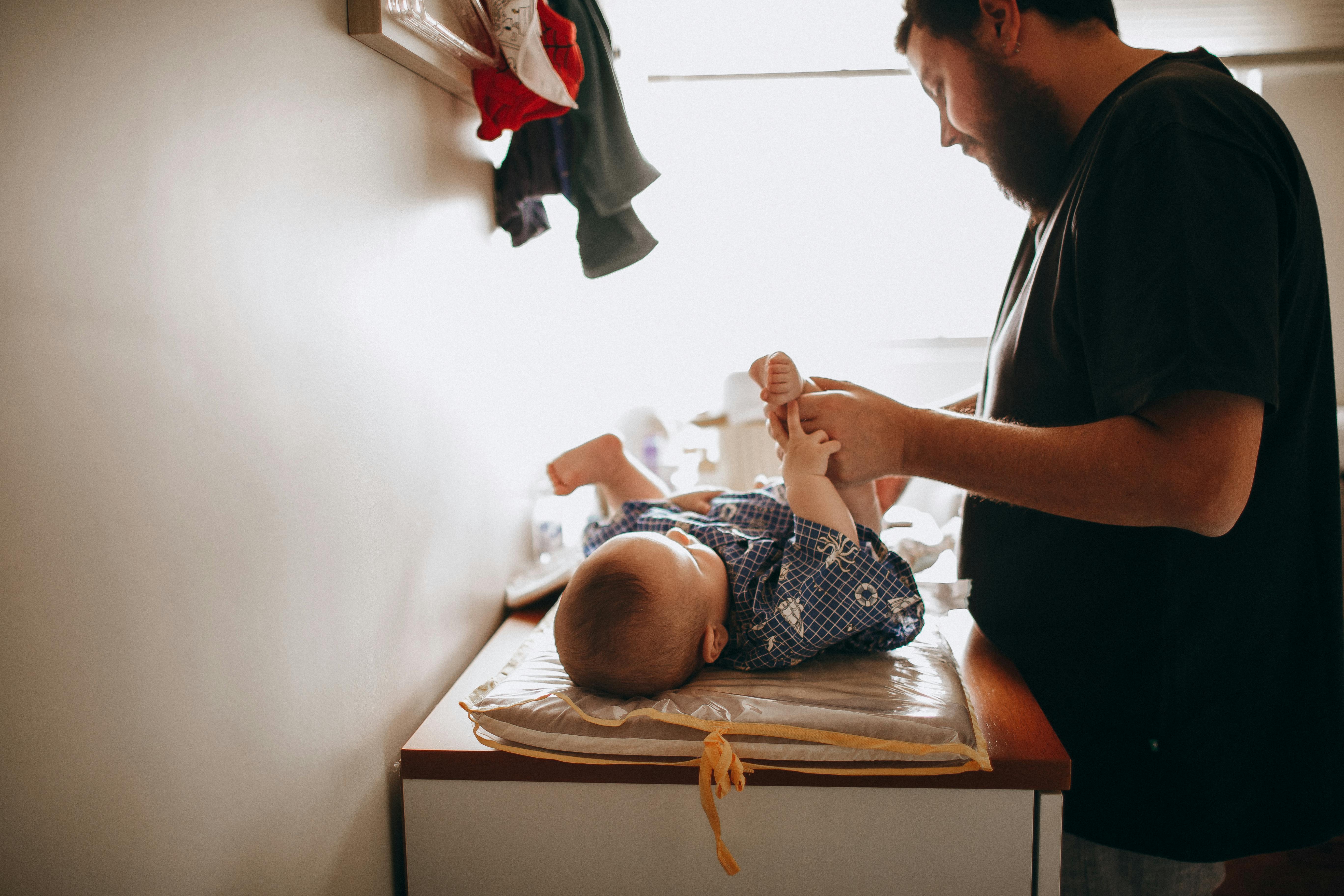 Ein Vater wechselt einem Baby die Windel | Quelle: Pexels