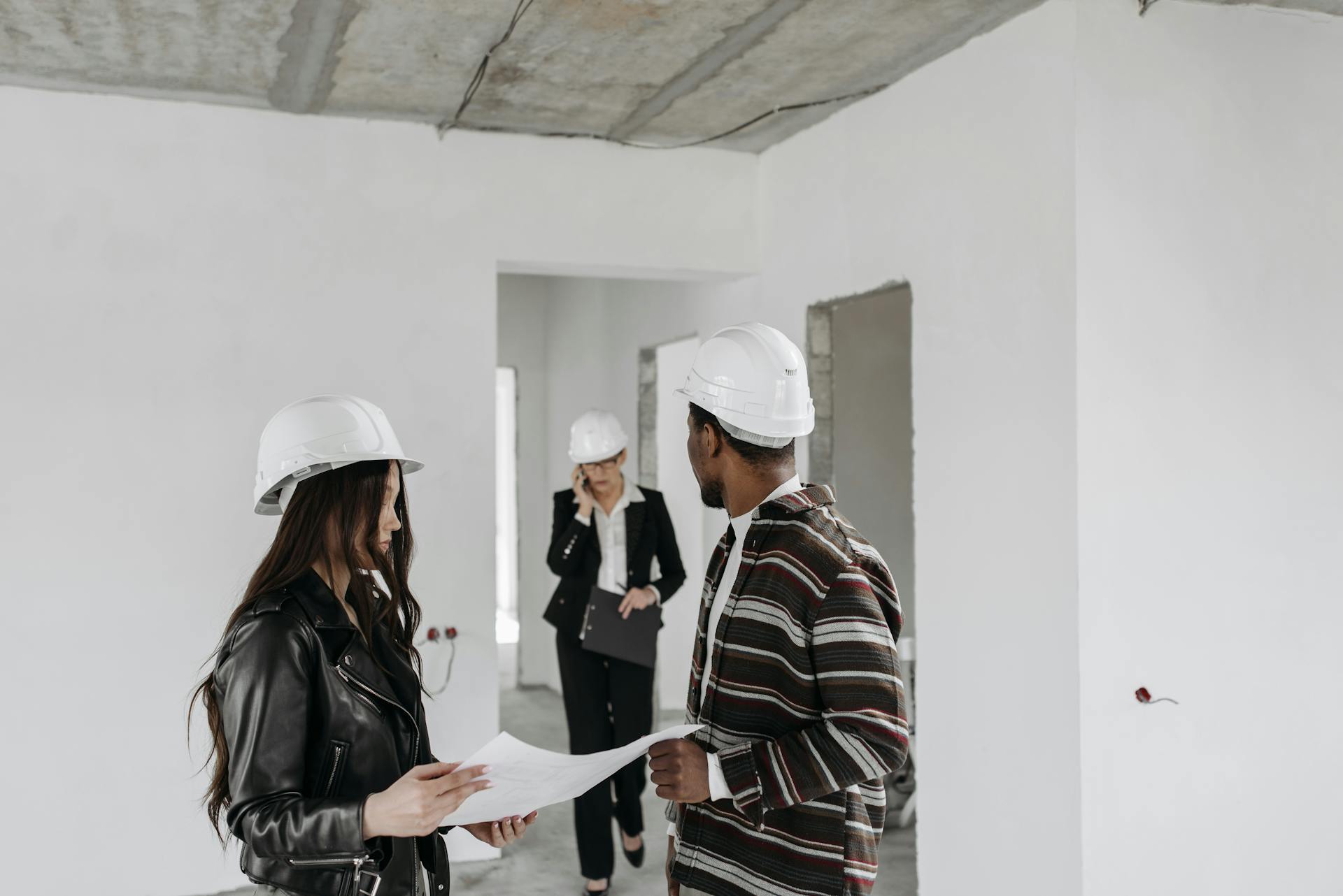Bauunternehmer besprechen Papierkram auf der Baustelle | Quelle: Pexels