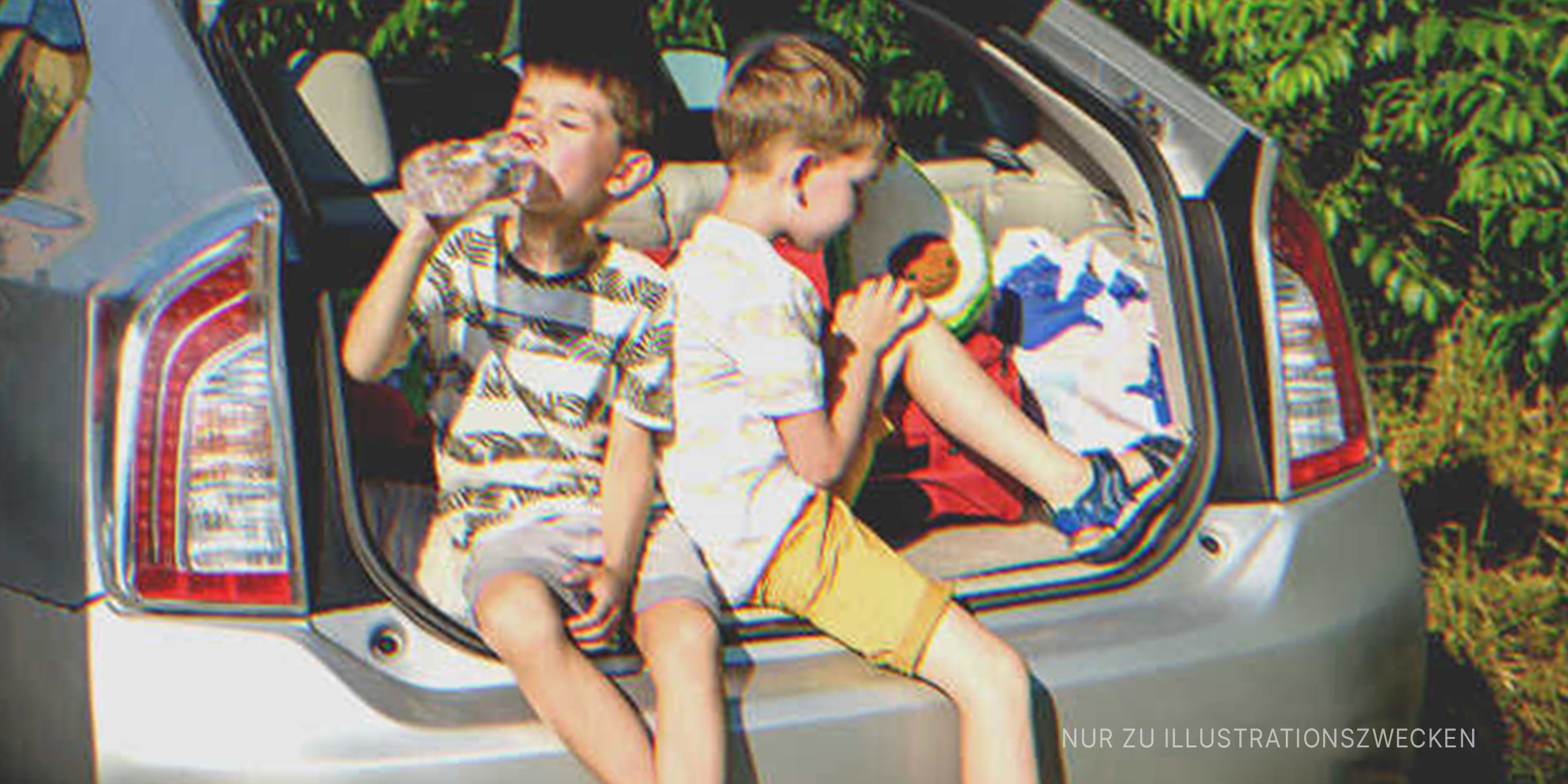 Zwei Jungs sitzen in einem Kofferraum | Quelle: Shutterstock