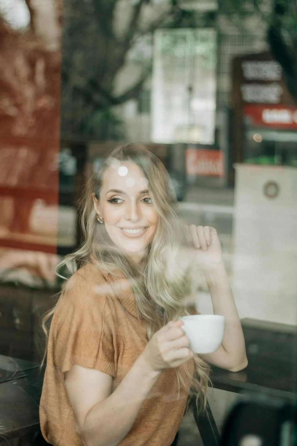 Eine lächelnde Frau beim Kaffeetrinken | Quelle: Pexels