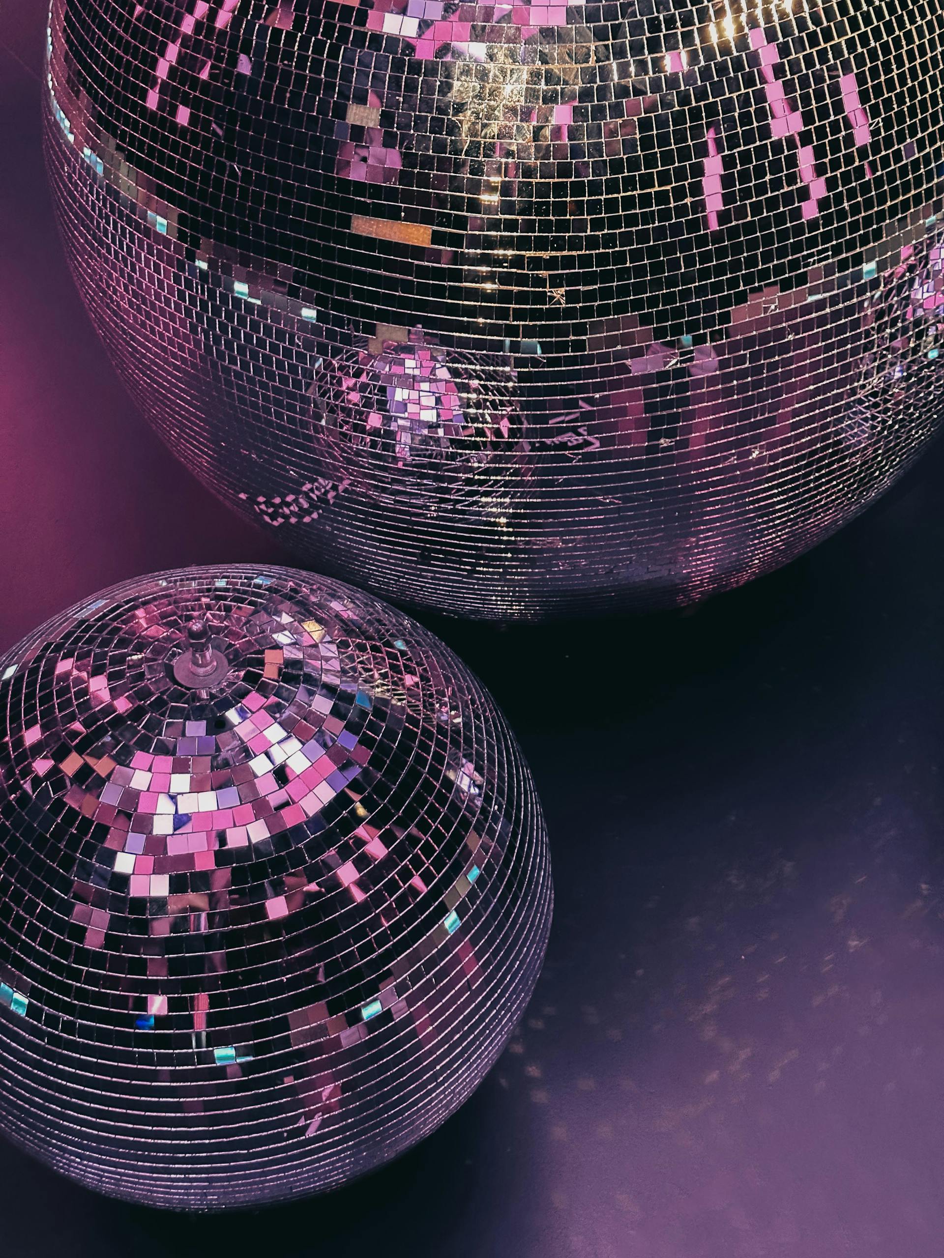 Eine Nahaufnahme von Discokugeln in lila Beleuchtung | Quelle: Pexels