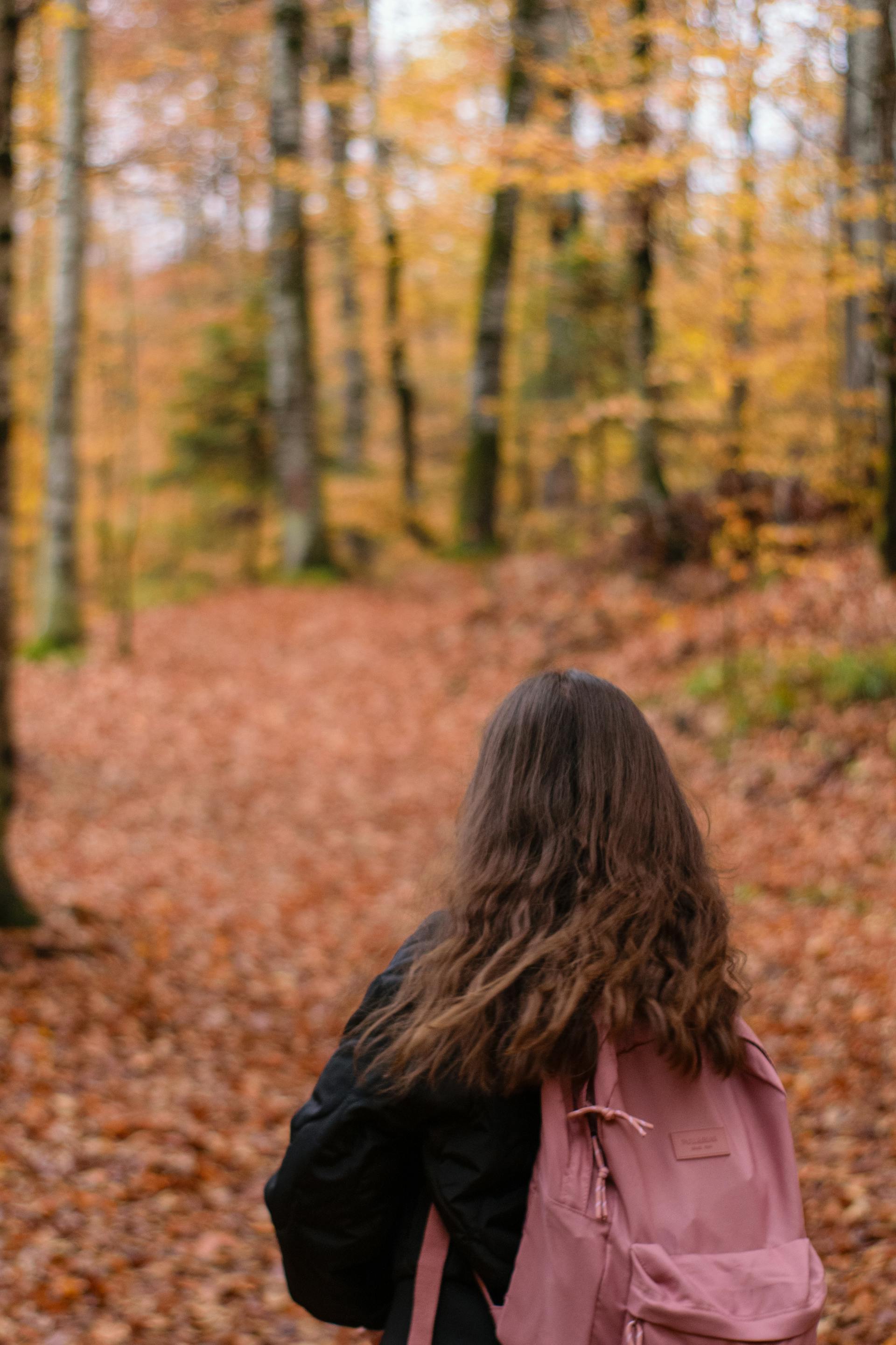 Eine Frau, die während der Herbstzeit in einem Park steht | Quelle: Pexels