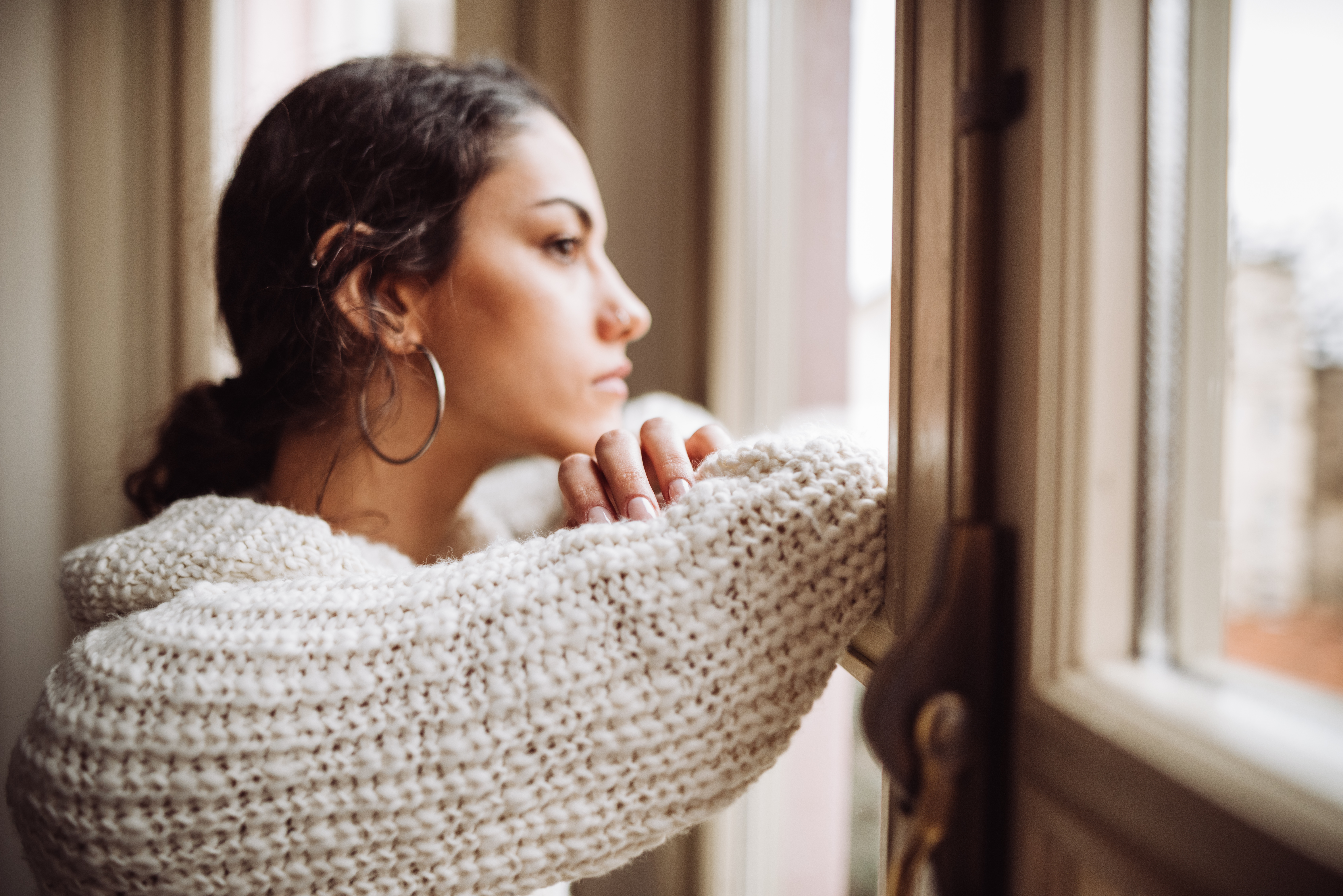 Eine nachdenkliche Frau vor dem Fenster | Quelle: Getty Images