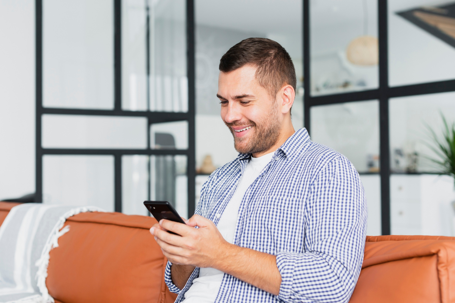 Ein Mann schaut auf sein Telefon und lächelt | Quelle: Freepik