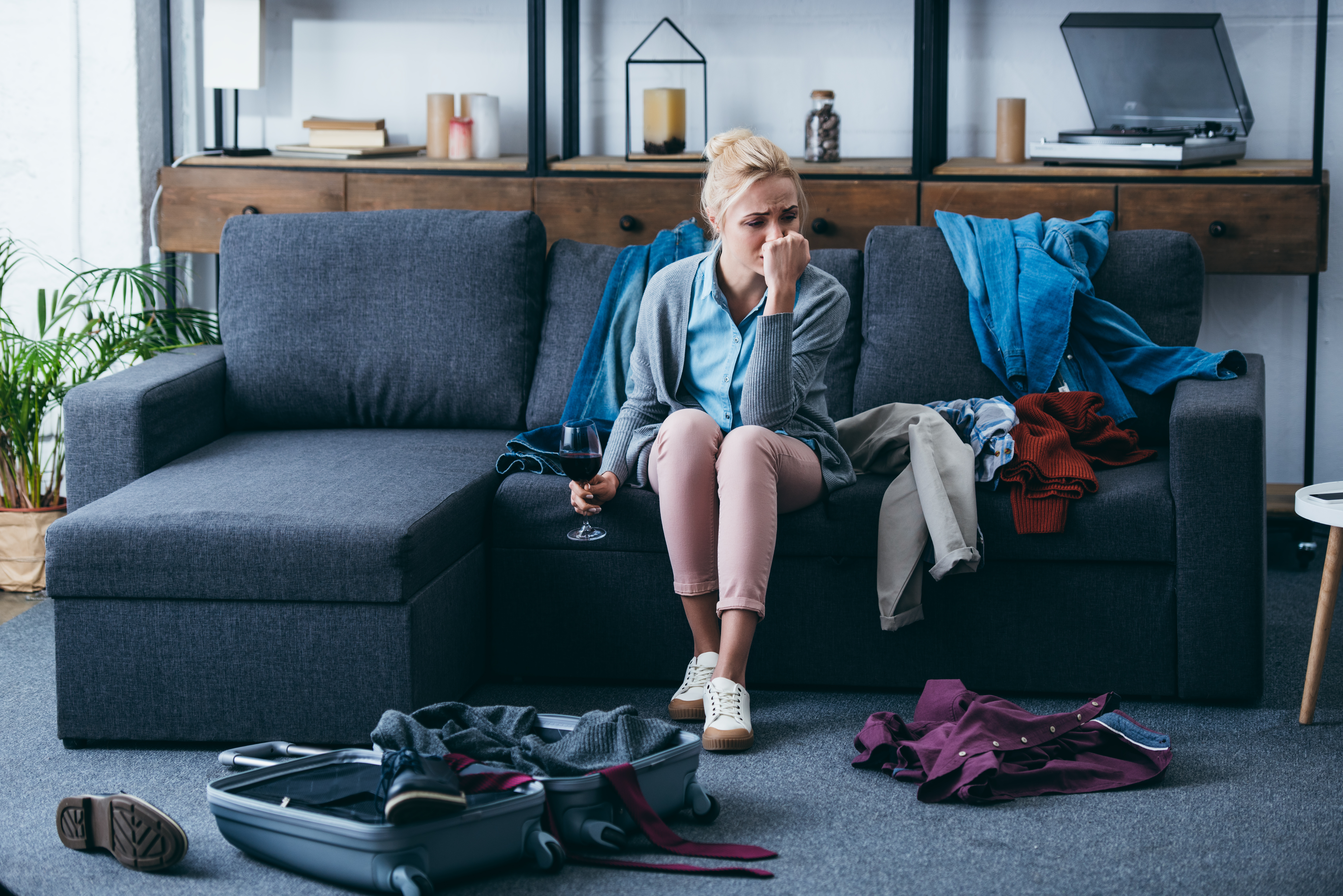 Eine traurig dreinblickende Frau beim Packen | Quelle: Shutterstock