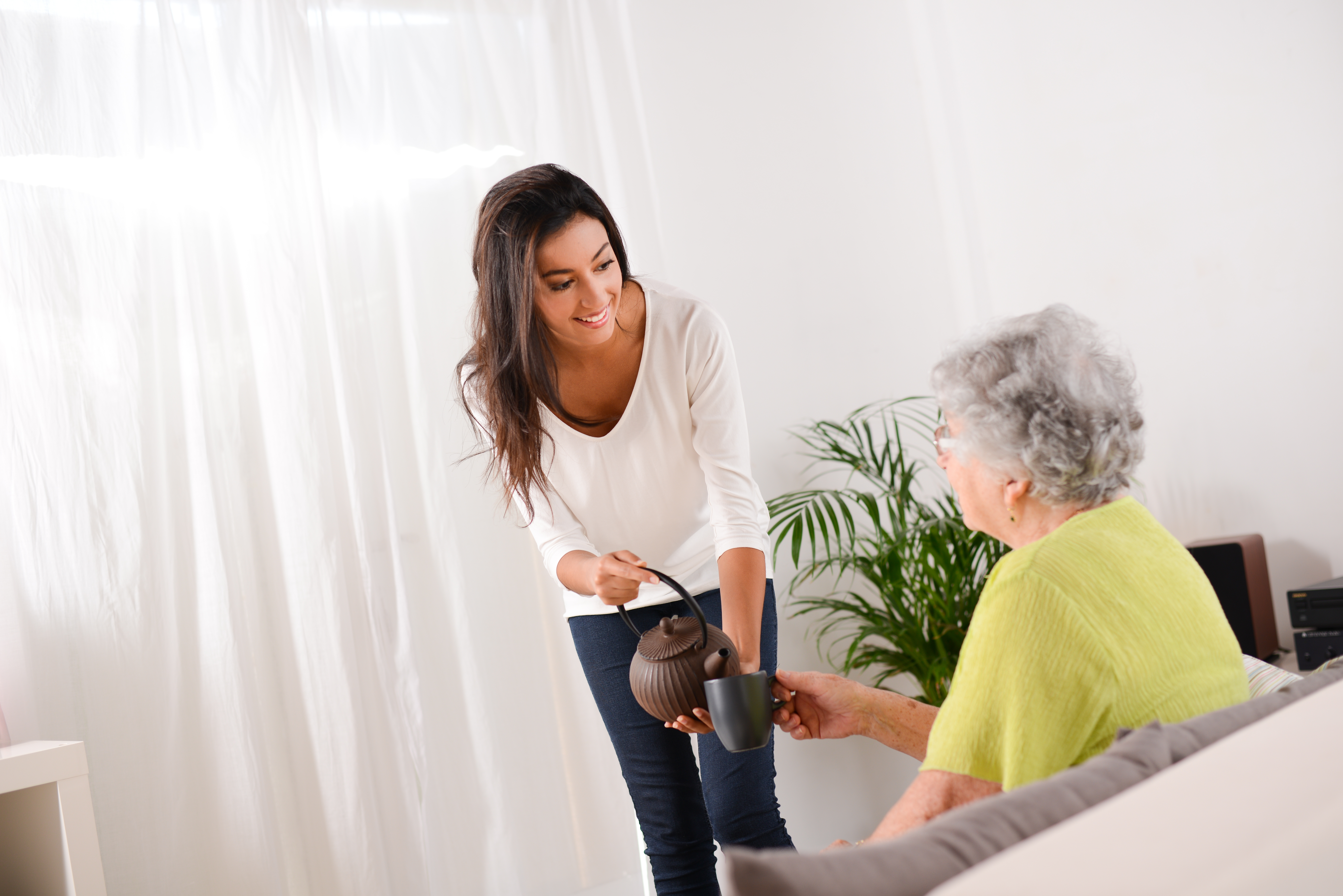 Eine Frau, die einer älteren Frau Tee bringt | Quelle: Shutterstock