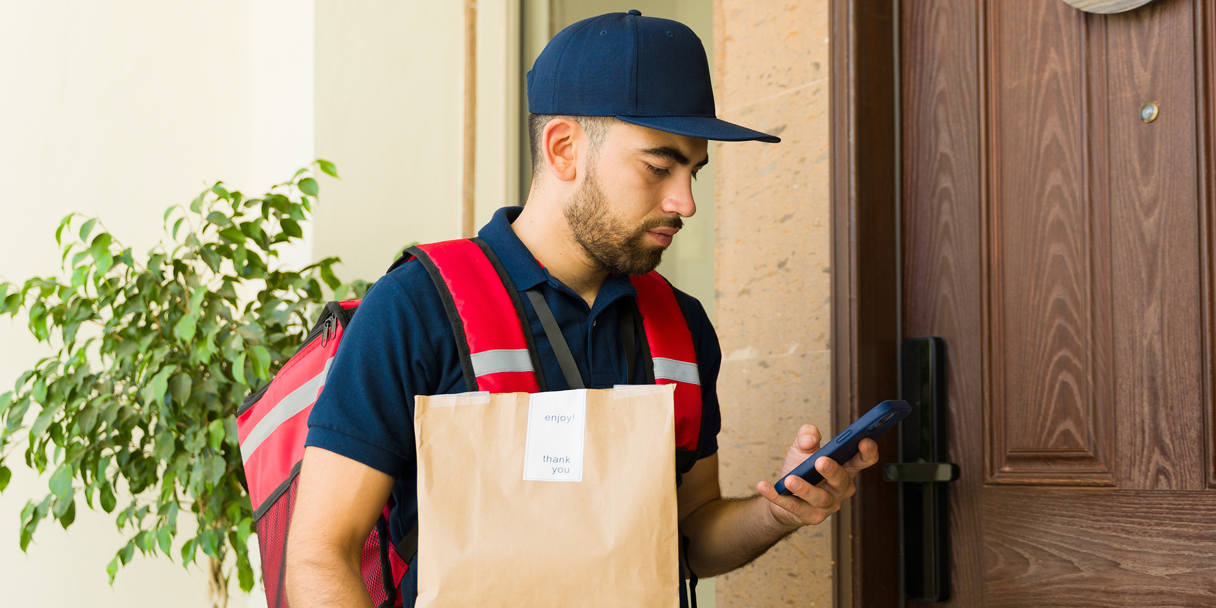 Ein Zusteller mit einem Telefon | Quelle: Shutterstock