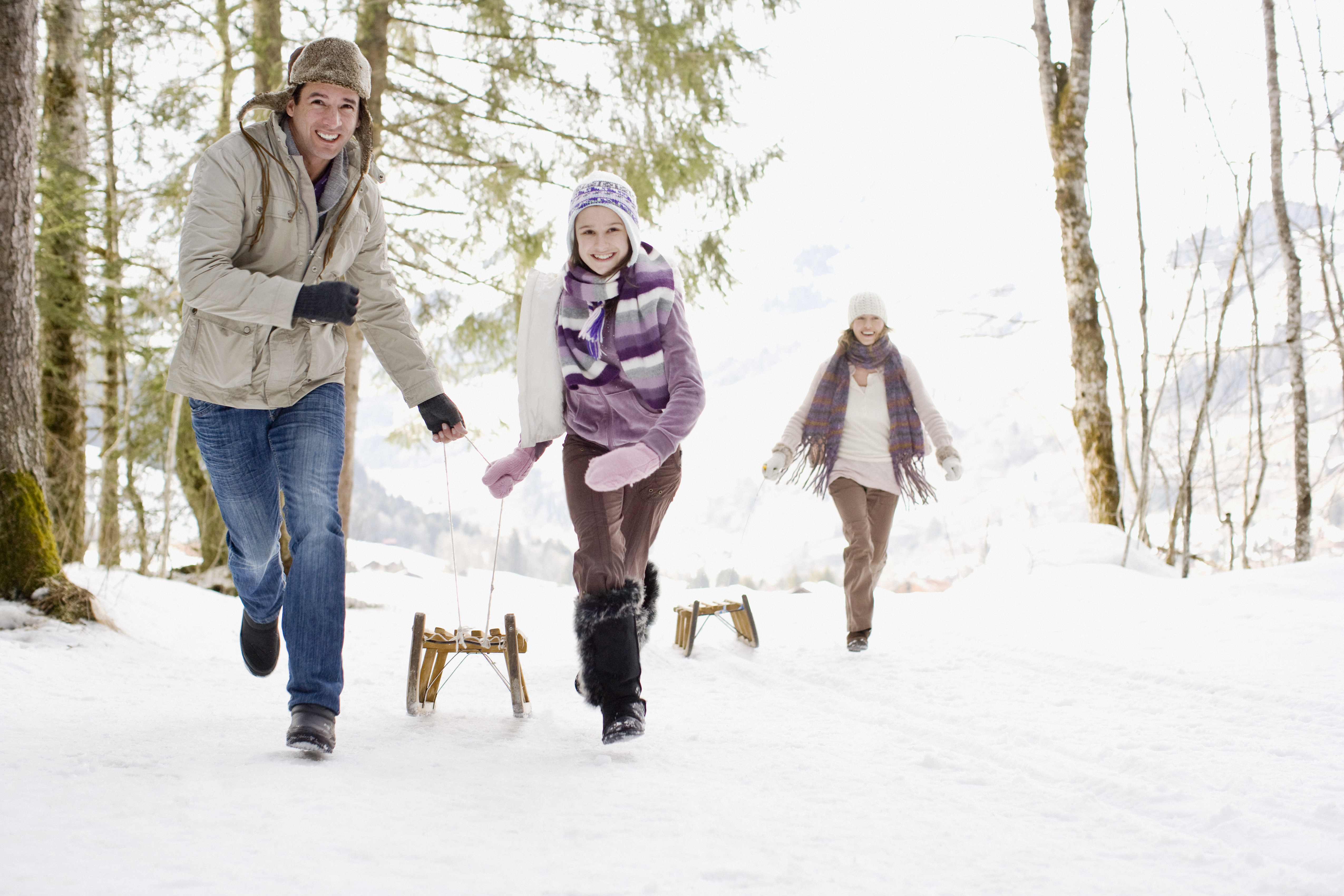 Familie, die Schlitten durch den Schnee zieht | Quelle: Getty Images