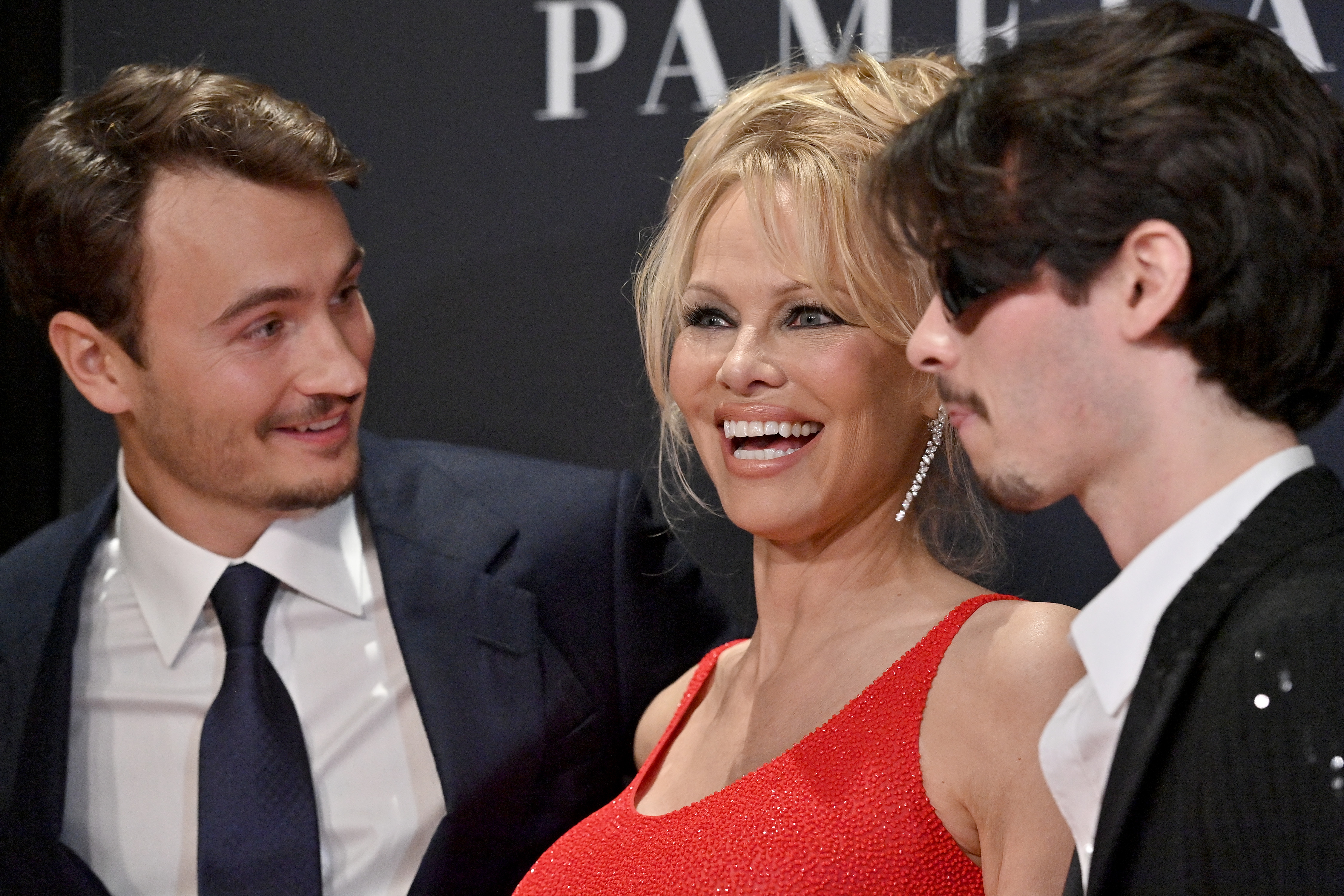 Pamela Anderson lächelt zwischen ihren Söhnen Brandon und Dylan Lee bei der Netflix-Premiere von "Pamela, A Love Story" in Kalifornien am 30. Januar 2023 | Quelle: Getty Images