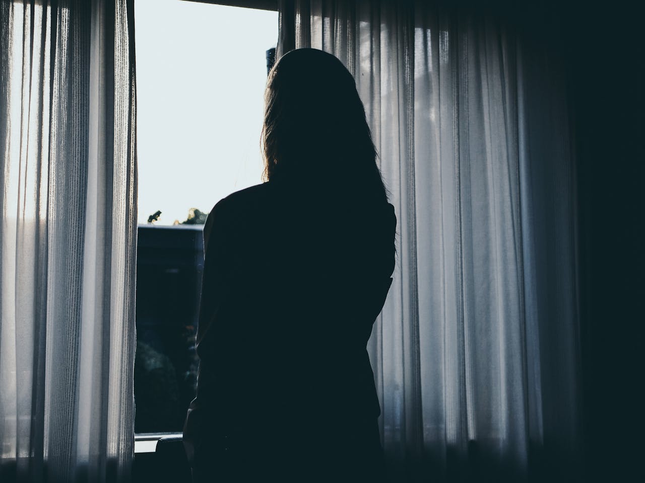 Silhouette einer Frau, die neben dem Fenster steht | Quelle: Pexels