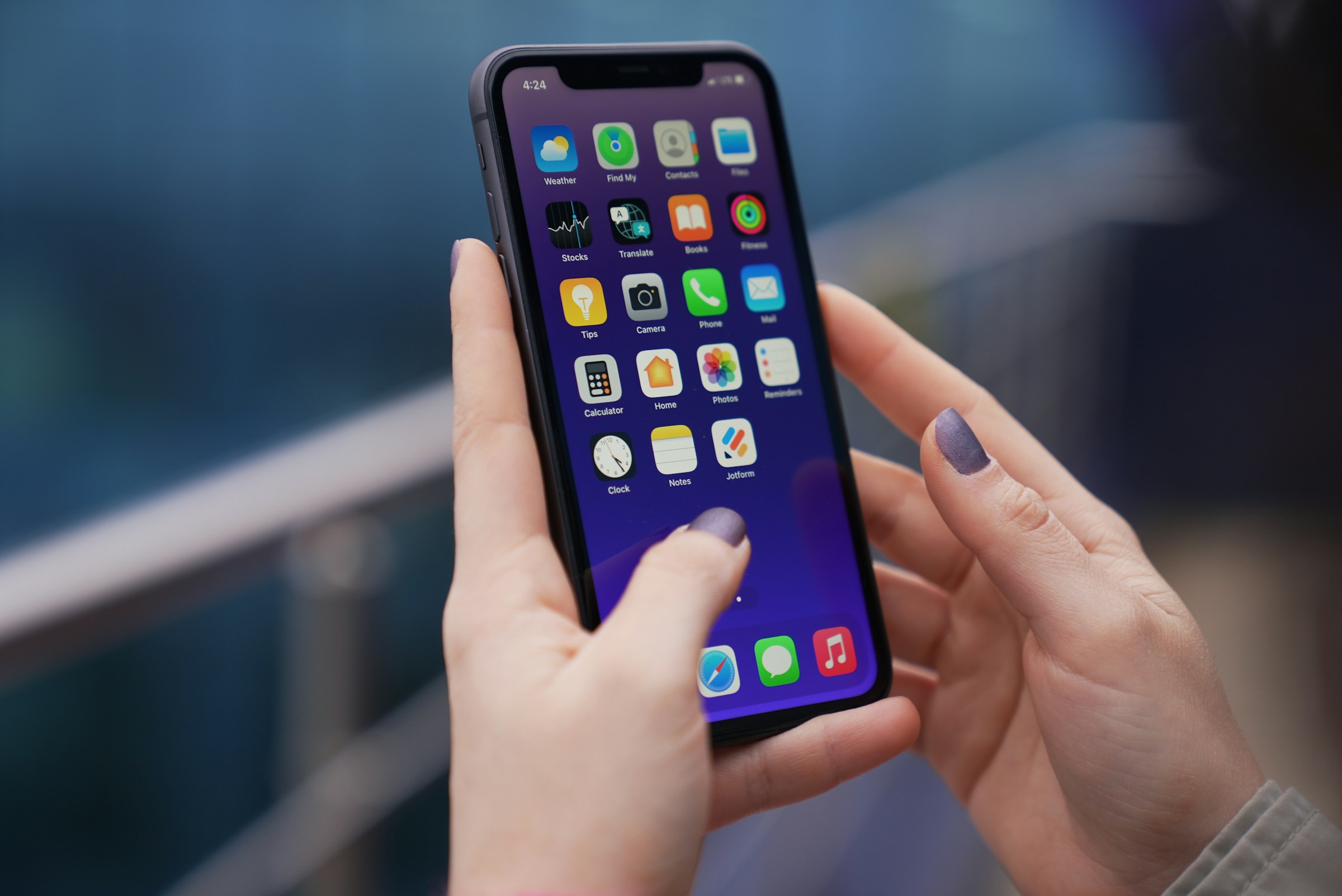 Eine Frau benutzt ihr Telefon an einem See | Quelle: Unsplash