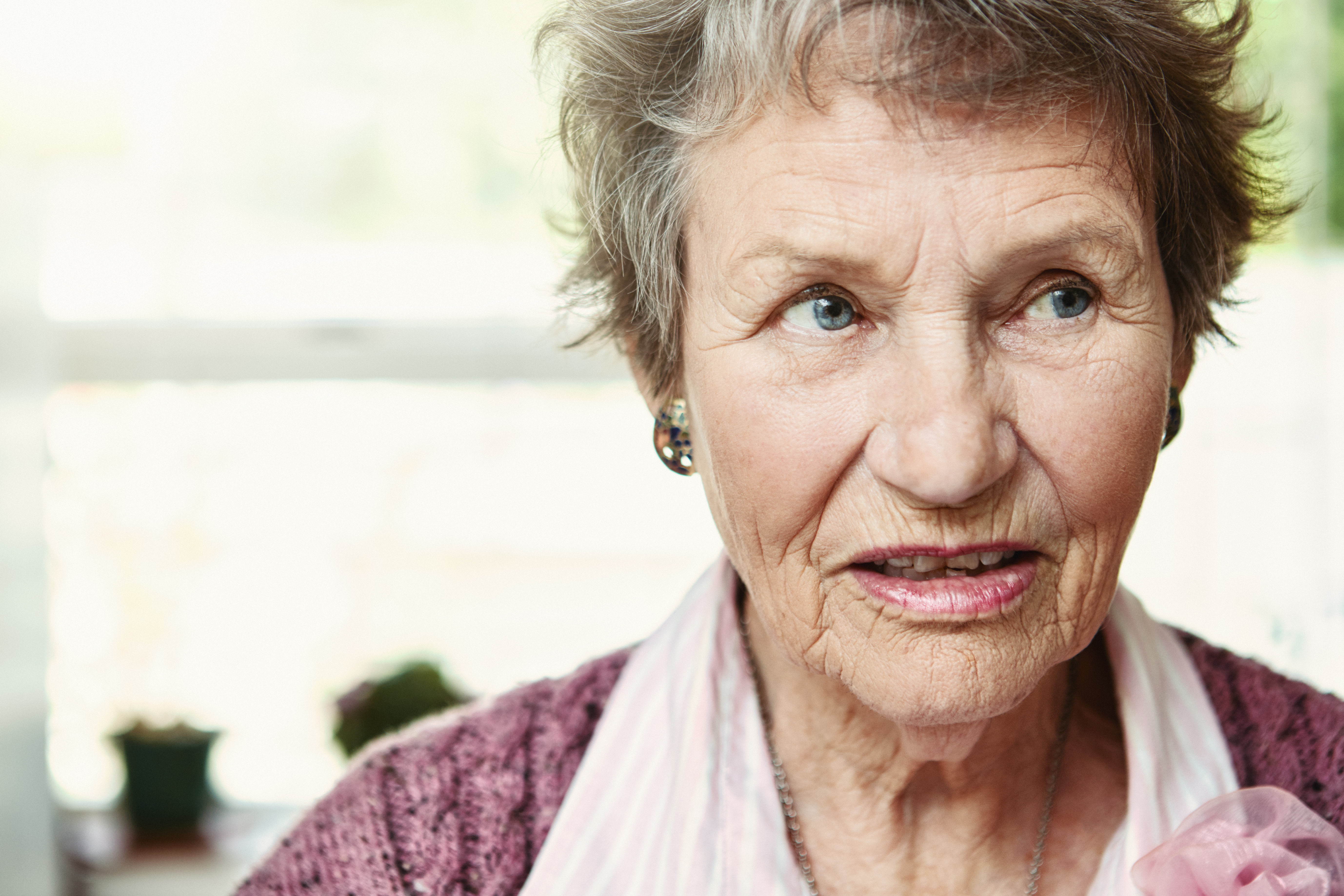 Eine ältere Frau in den 80ern blickt verwirrt und ängstlich weg | Quelle: Getty Images
