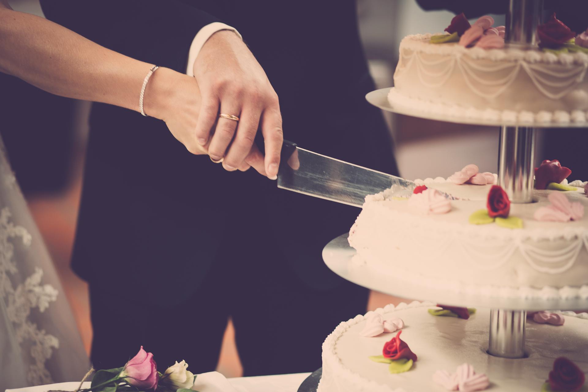 Ein Paar schneidet die Torte an seinem Hochzeitstag an | Quelle: Pexels