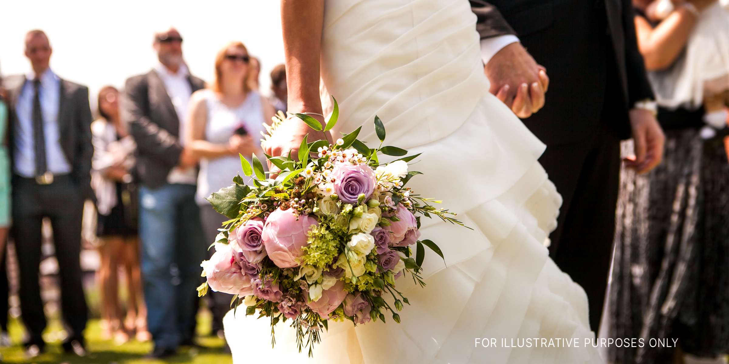 Eine Braut und ein Bräutigam halten sich bei ihrer Hochzeit an den Händen | Quelle: Shutterstock