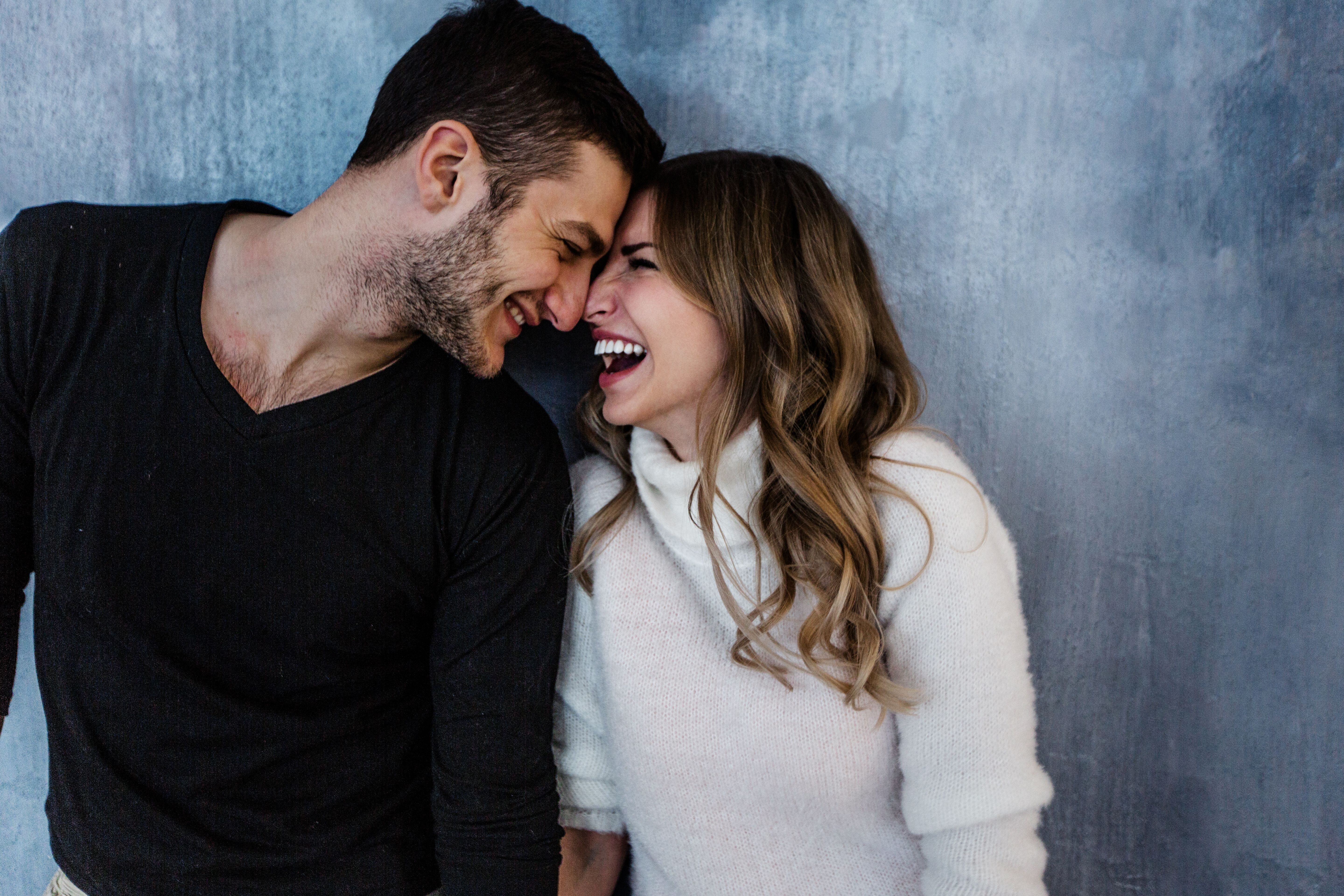Ein Mann und eine Frau lächeln sich an, wobei sich ihre Stirnen berühren | Quelle: Shutterstock