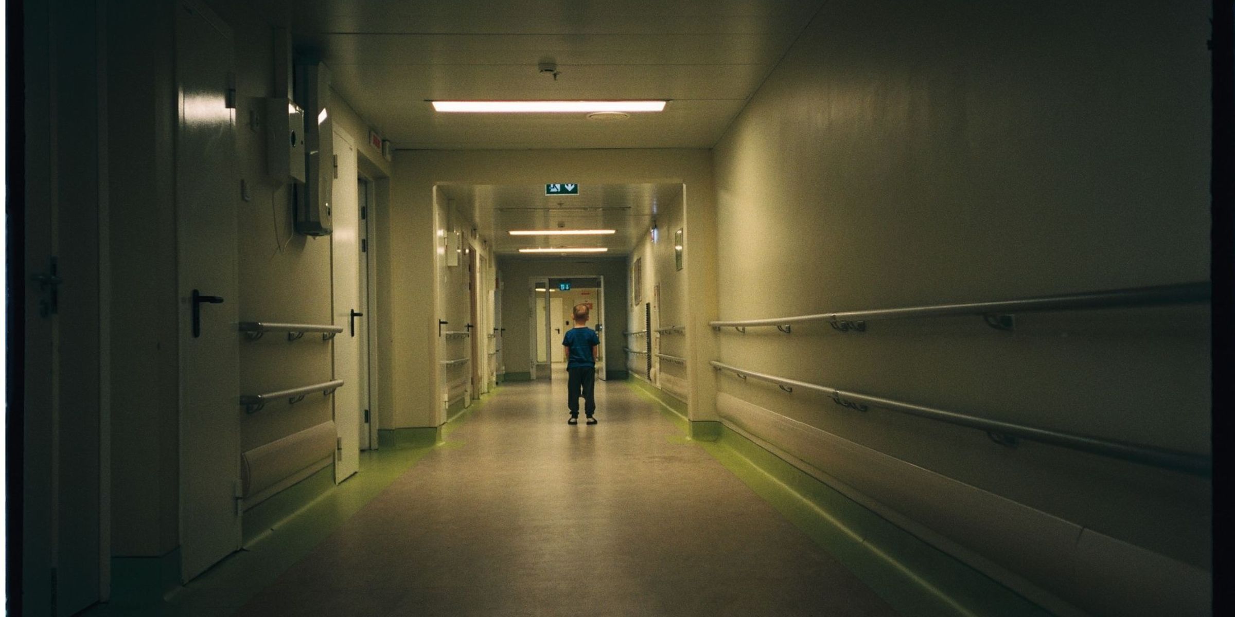 Kleines Kind, das allein in einem schummrigen Krankenhausflur steht | Quelle: Pexels