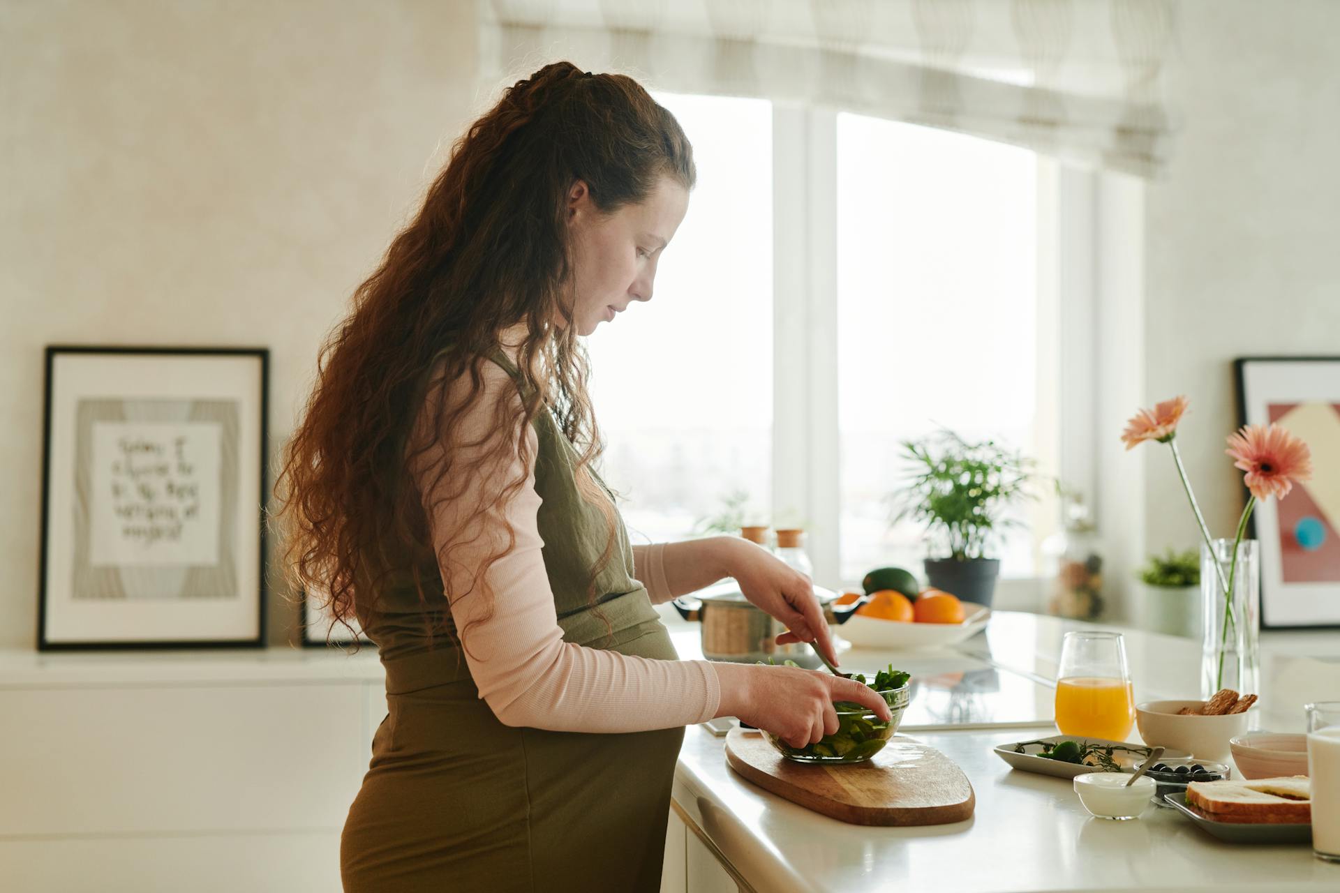 Eine schwangere Frau, die auf dem Küchentisch Essen zubereitet | Quelle: Pexels