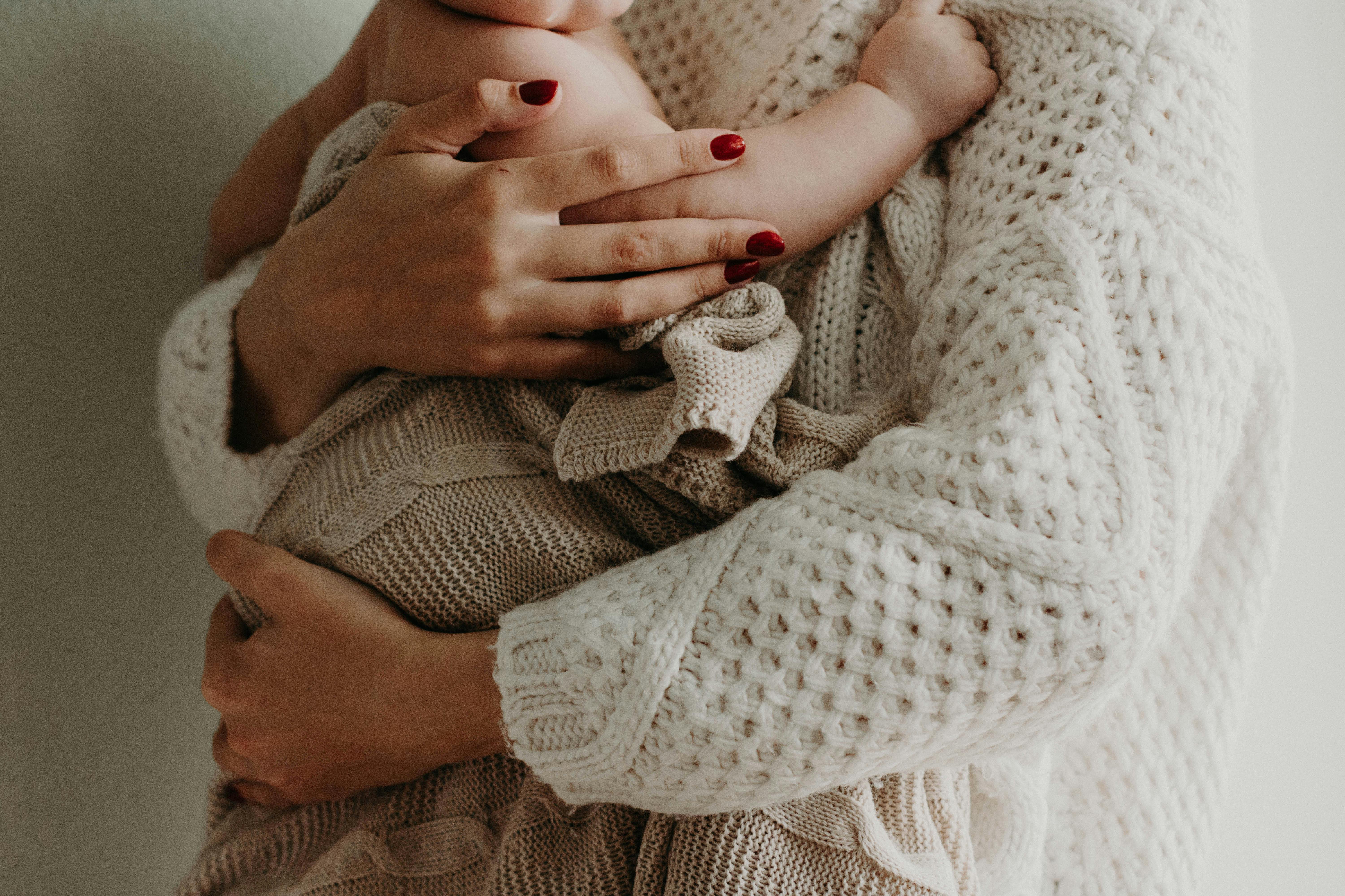Eine Mutter, die ihr Baby in den Arm nimmt | Quelle: Pexels