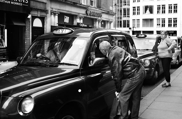 Ein Mann im Gespräch mit einer Frau im Auto.| Quelle: Getty Images