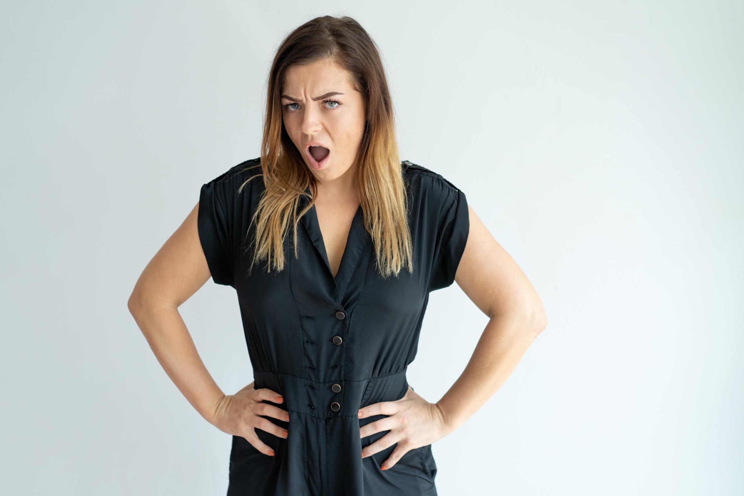 Eine wütende Frau mit den Händen in den Hüften | Quelle: Freepik