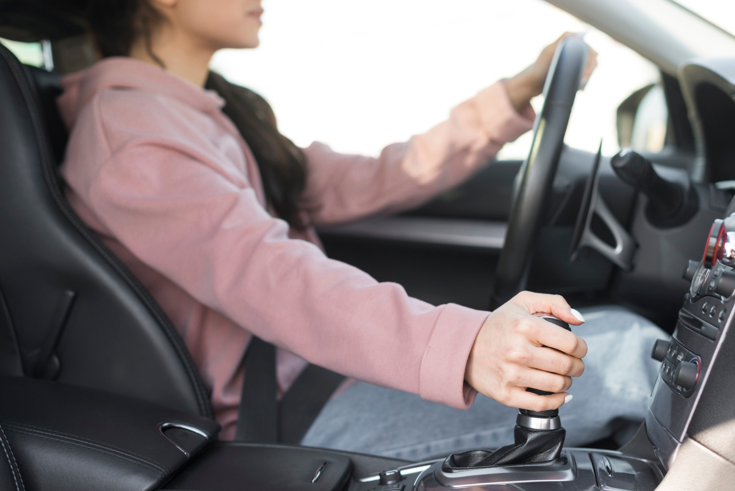Eine Frau, die beim Autofahren schaltet | Quelle: Freepik