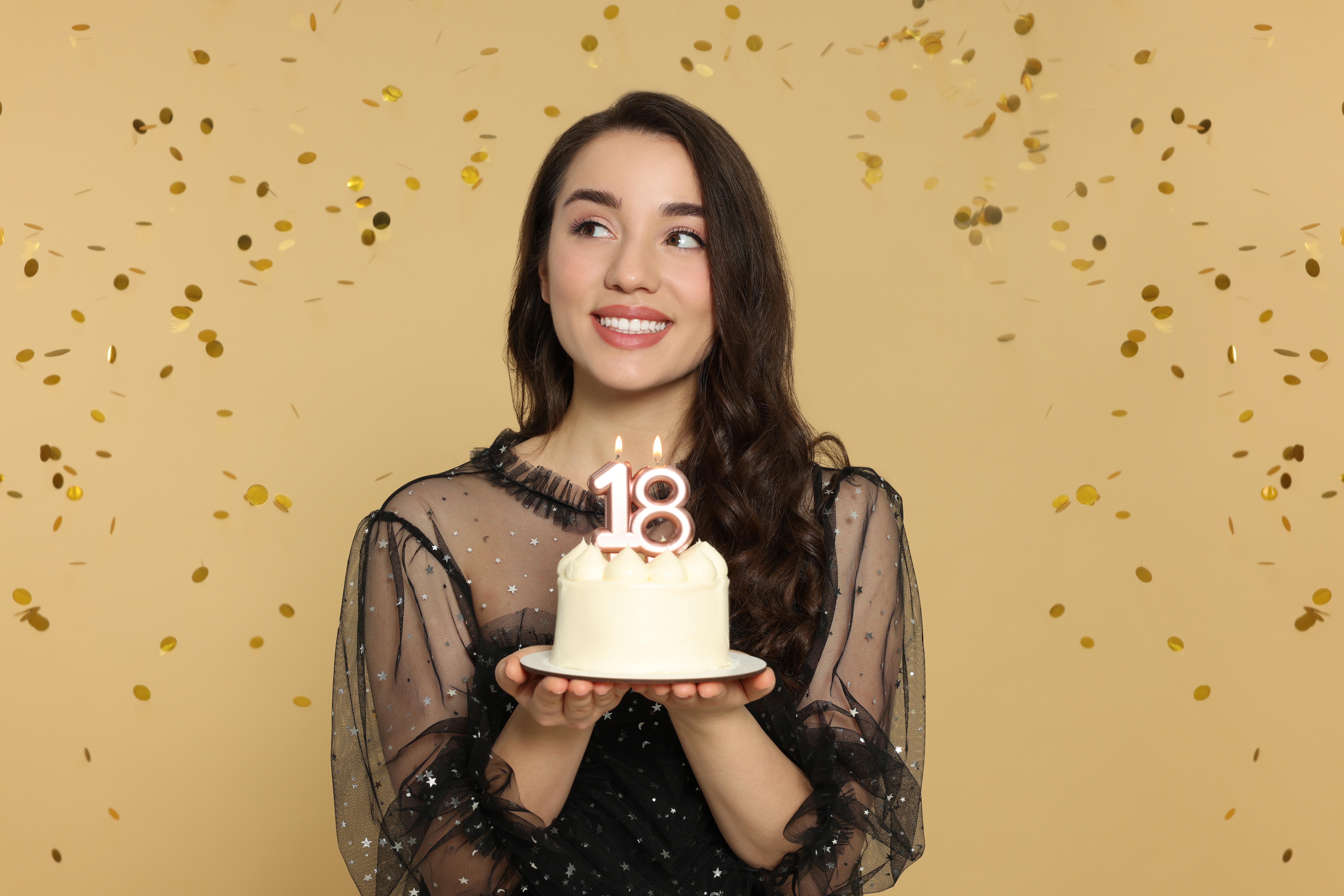 Junge Frau hält ihre Torte zum 18. Geburtstag | Quelle: Shutterstock
