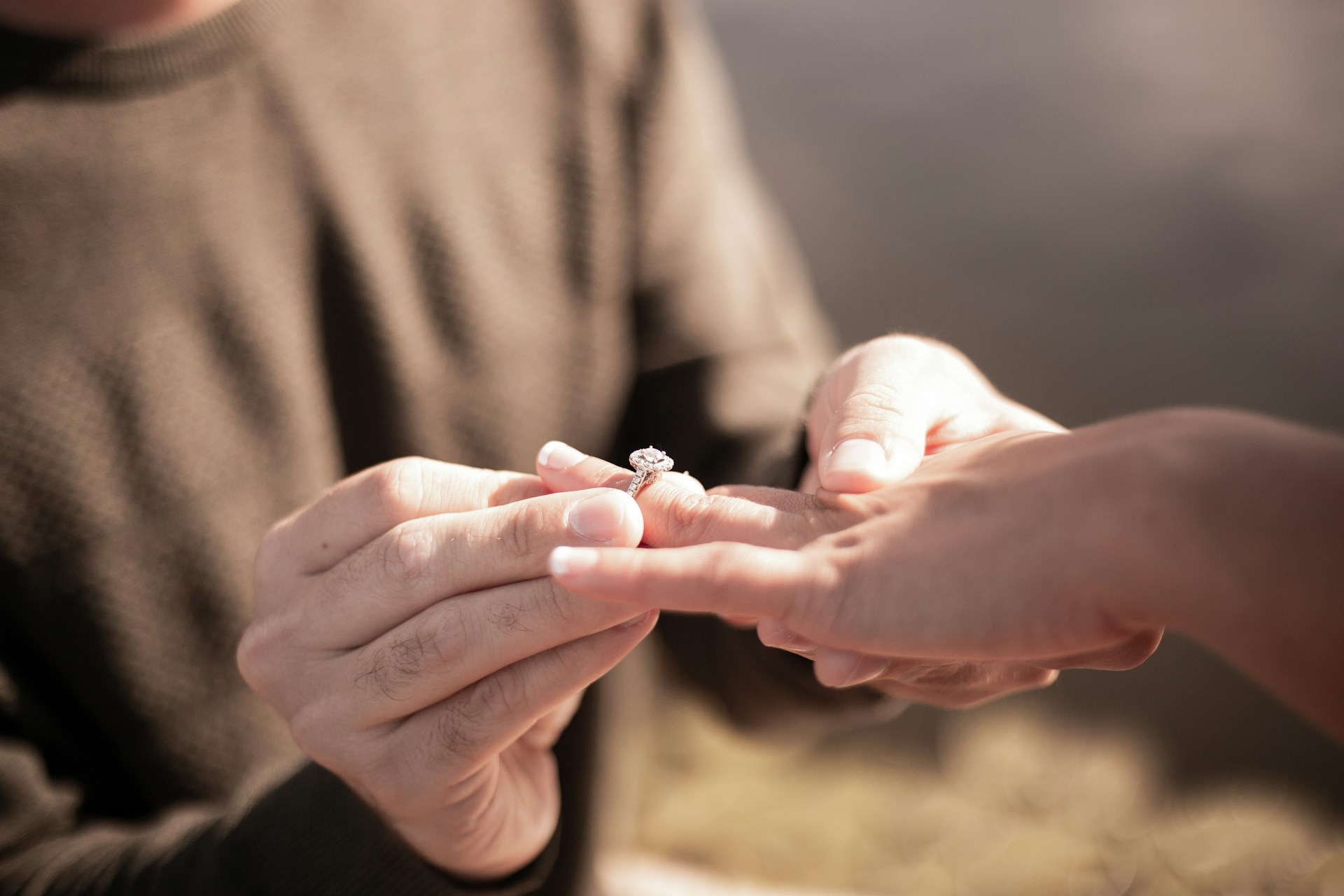 Nahaufnahme eines Mannes, der einer Frau einen Ring an den Finger steckt | Quelle: Unsplash