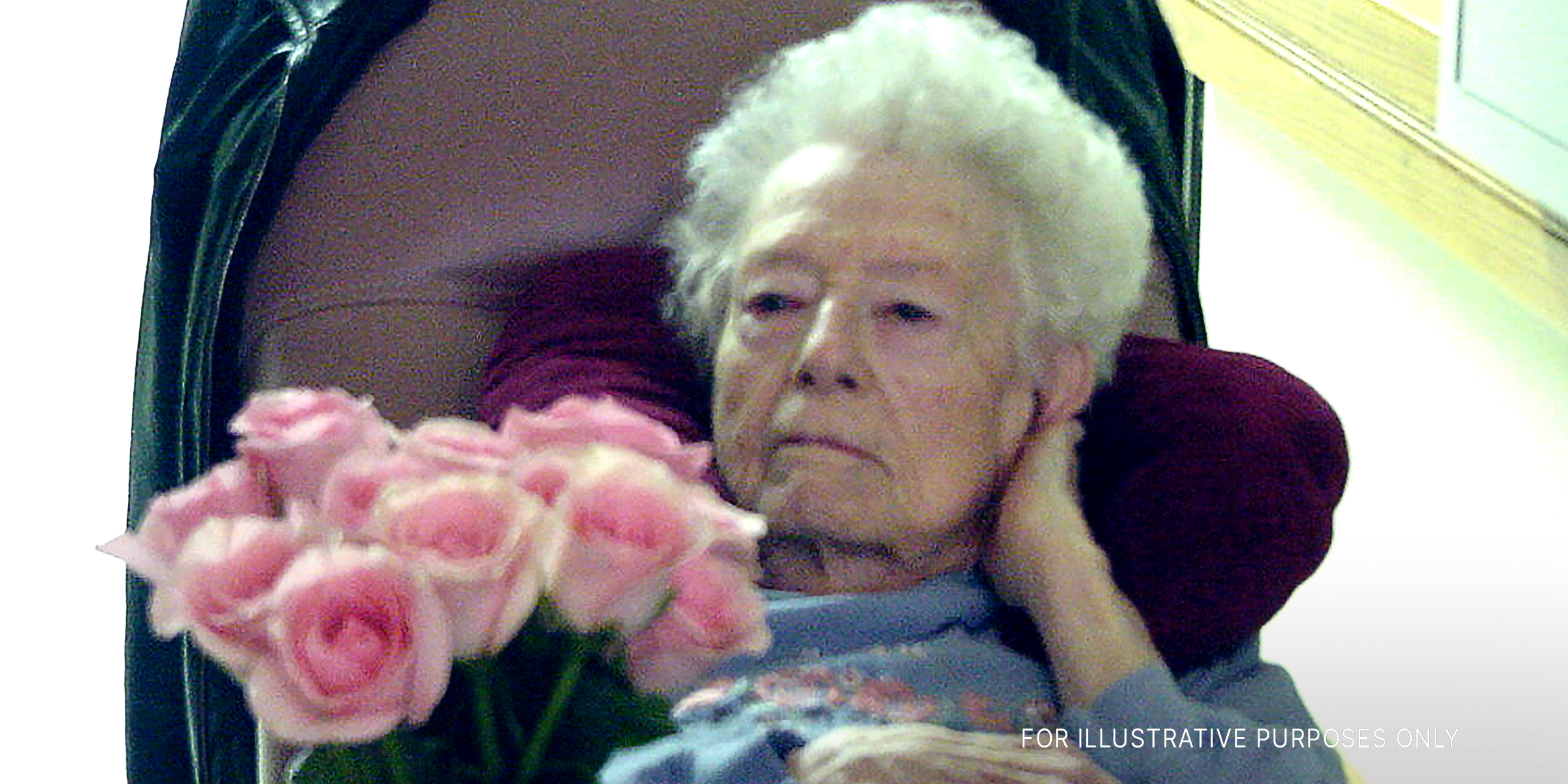 Eine alte Frau hält Rosen | Quelle: Getty Images