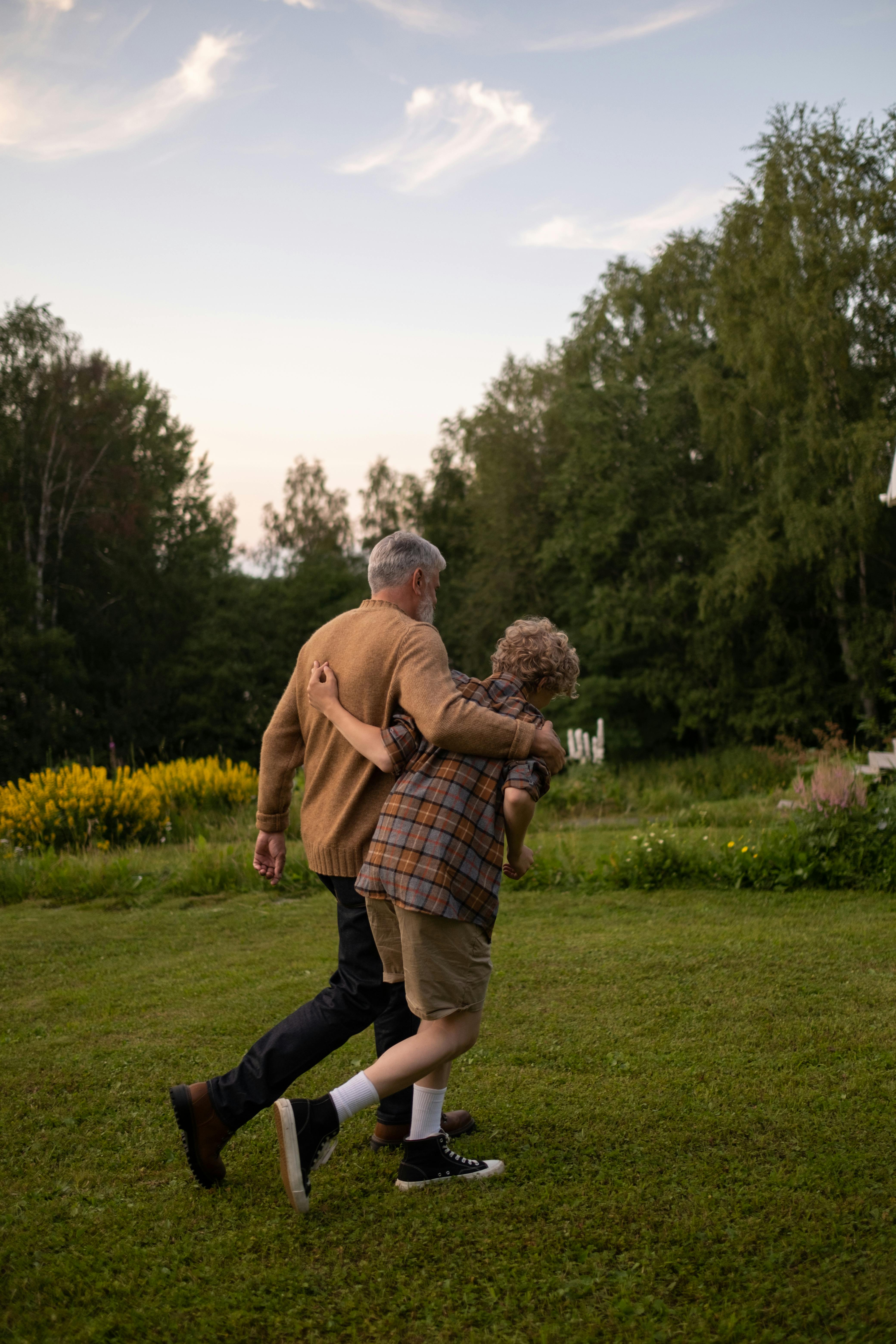 Großvater und Enkel gehen in einem Garten spazieren | Quelle: Pexels