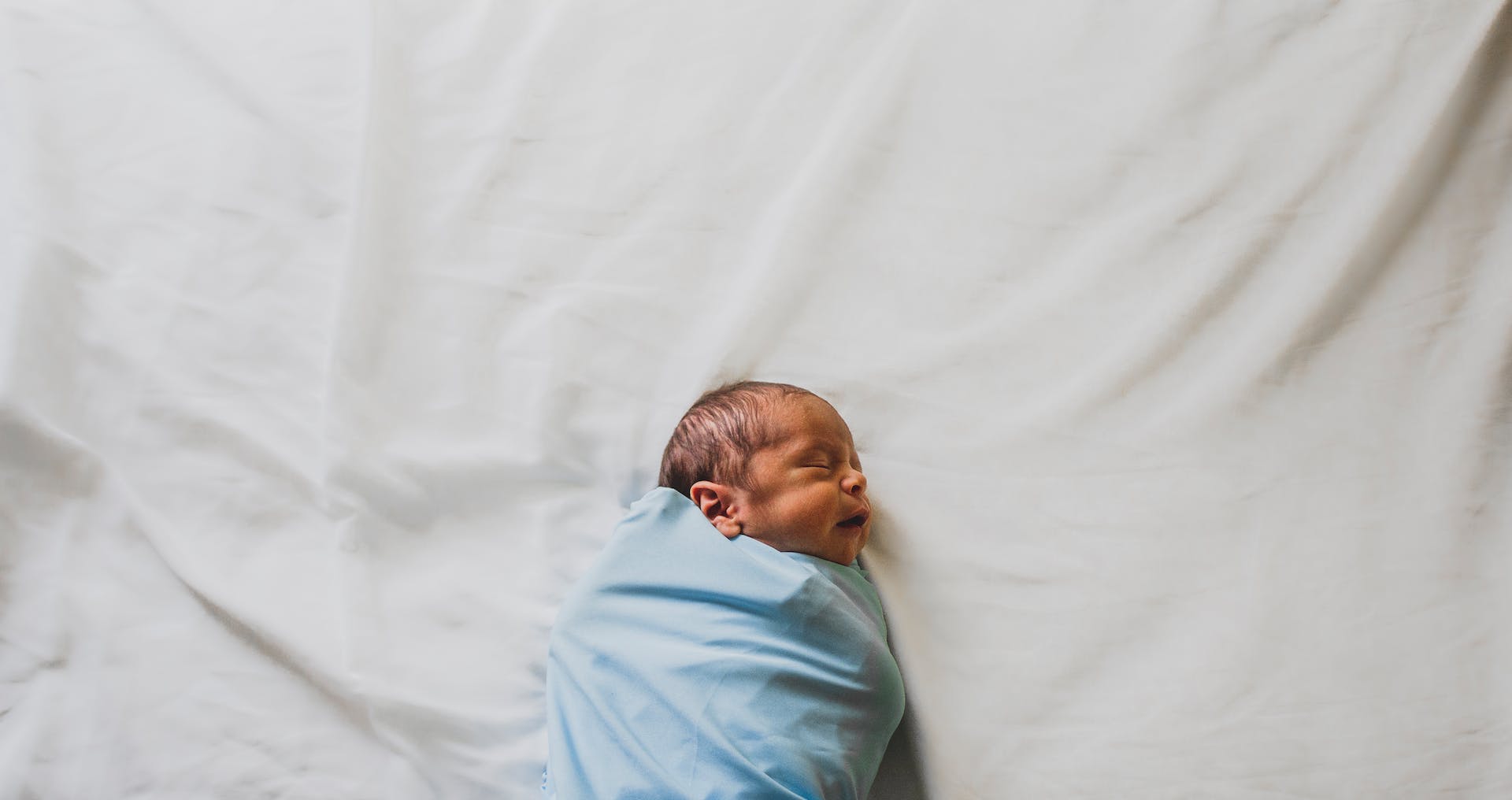 Neugeborener Junge, eingewickelt in eine blaue Decke | Quelle: Pexels