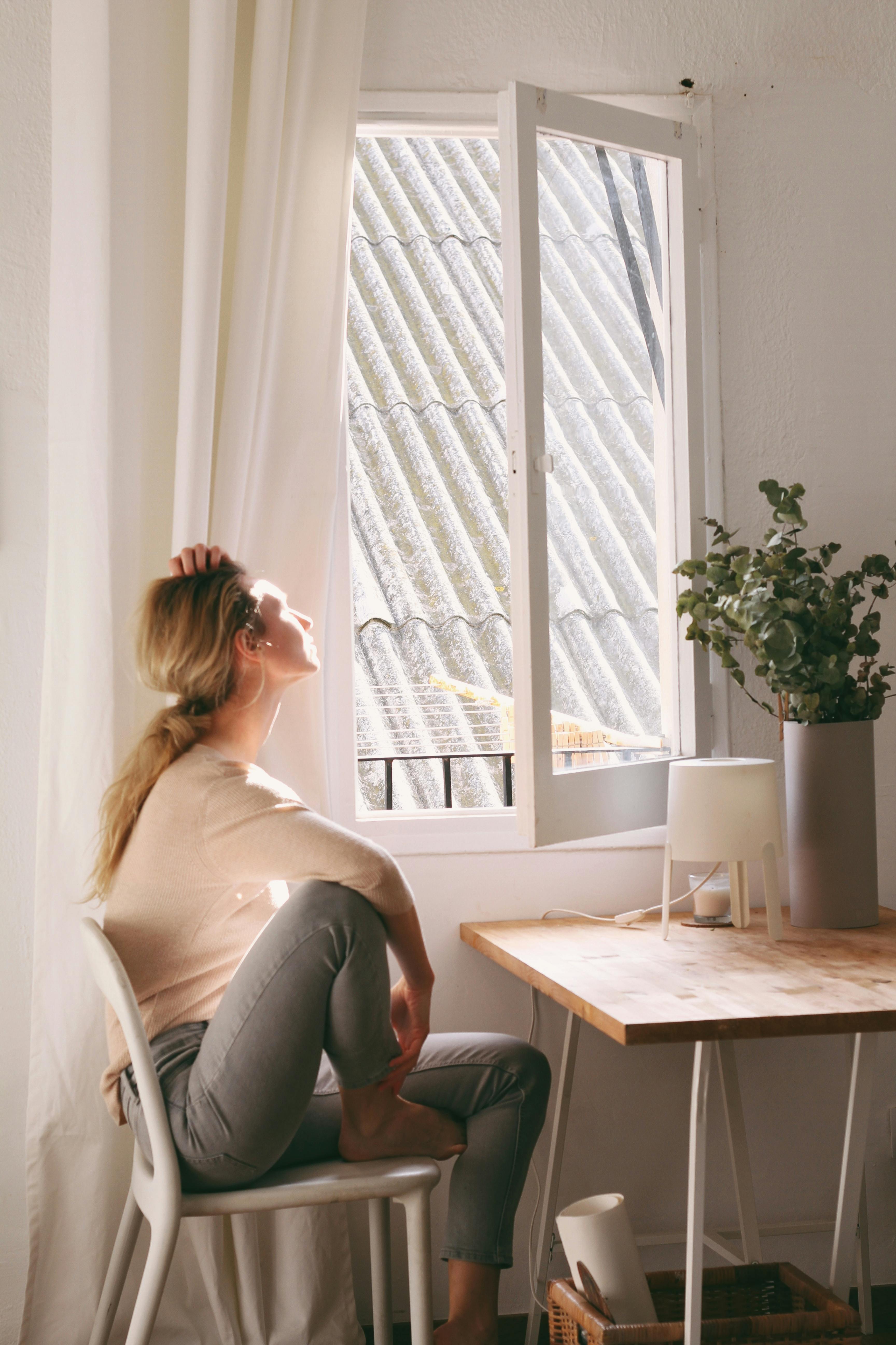 Eine Frau schaut nachdenklich aus dem Fenster | Quelle: Pexels