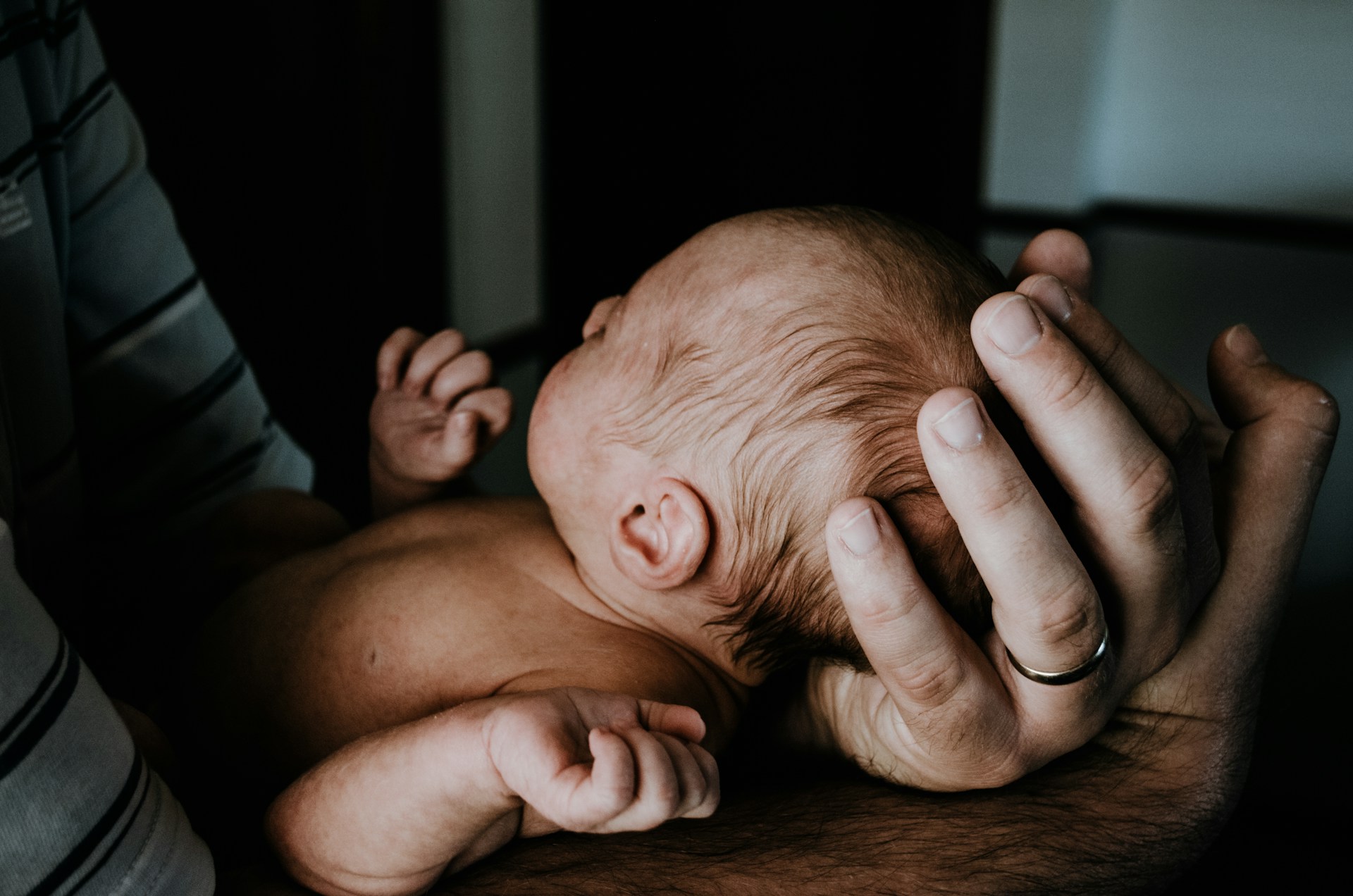 Ein emotional überwältigter Mann, der ein neugeborenes Baby hält | Quelle: Unsplash