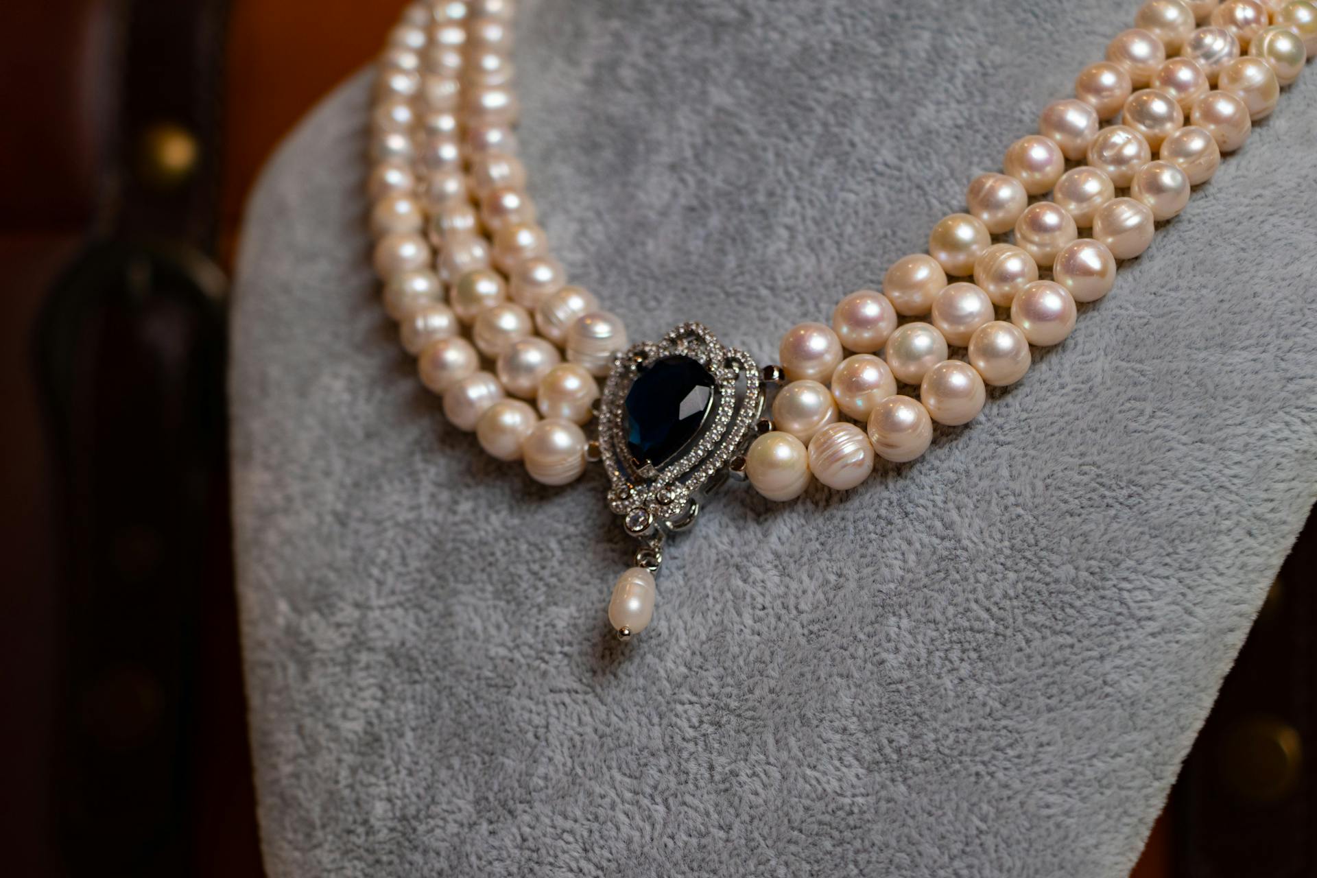 Eine Perlenkette mit einem dunklen Edelstein | Quelle: Pexels