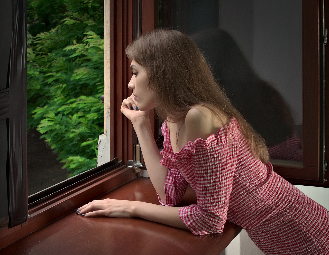 Junge Frau lehnt am Fenster | Quelle: Pixabay