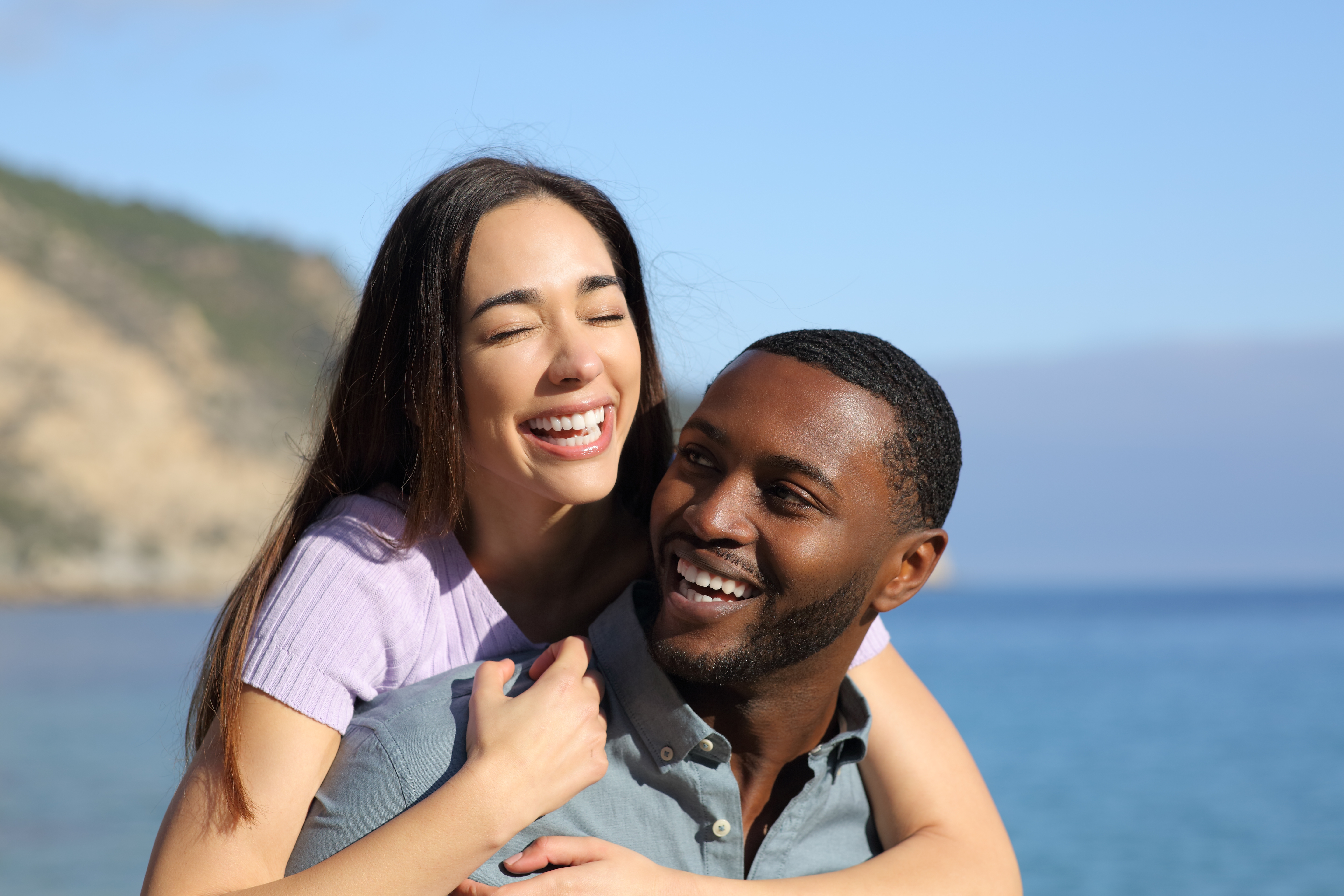 Ein glückliches gemischtrassiges Paar wird am Strand abgebildet | Quelle: Shutterstock