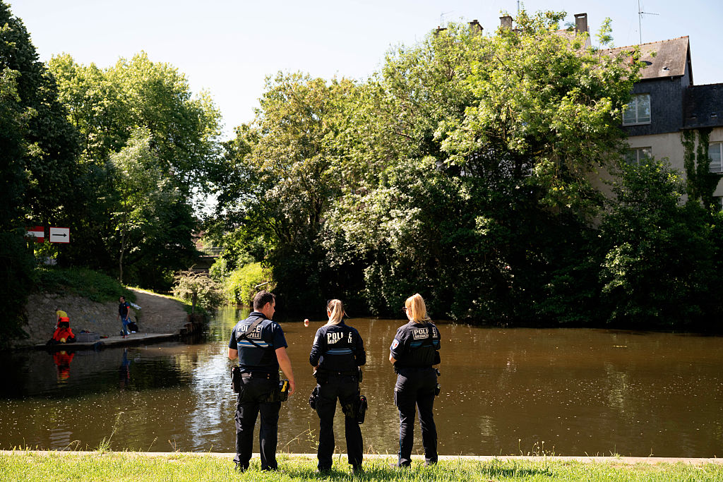 Polizisten beobachten Taucher bei der Suche nach Beweismitteln im Fluss Vilaine in der Nähe der Stelle, an der am Vortag in Rennes die Leiche eines 12-jährigen Jungen gefunden wurde (25. Mai 2026). | Quelle: Getty Images