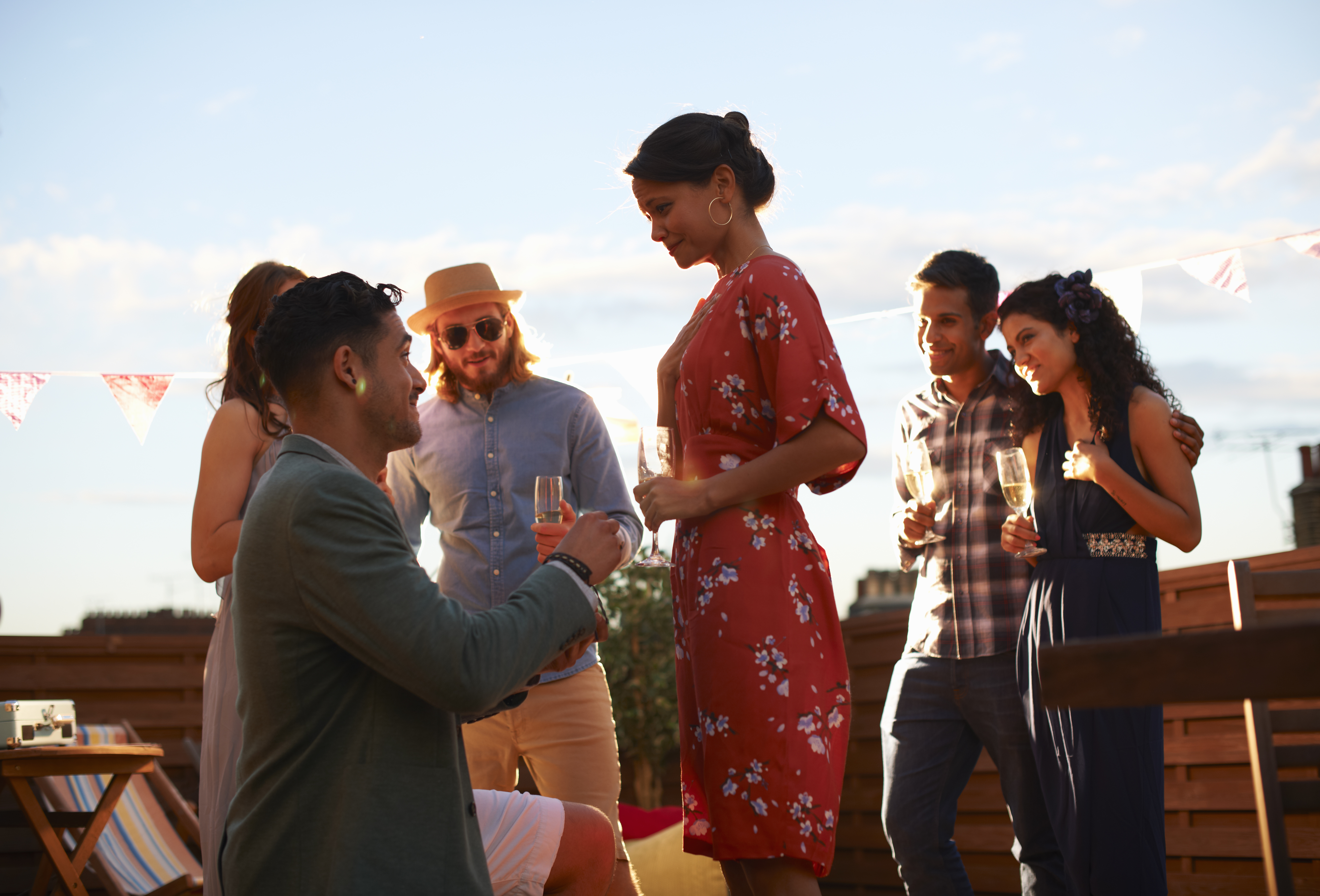 Ein Mann macht einer Frau vor ihren Freunden einen Heiratsantrag | Quelle: Getty Images