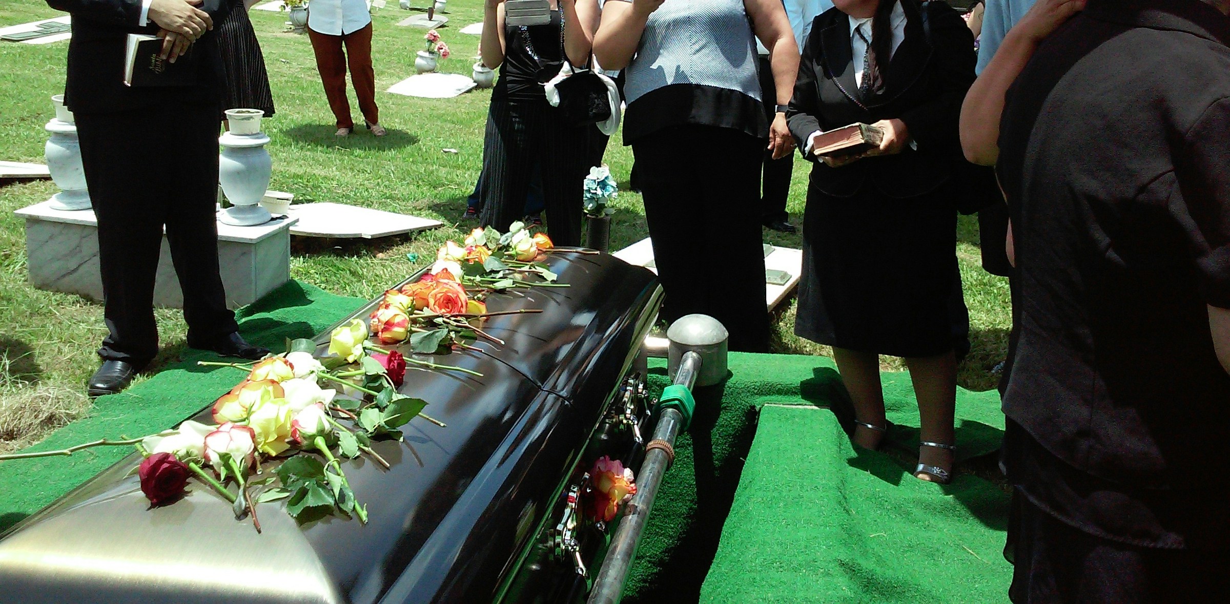 Menschen, die einer Beerdigung beiwohnen | Quelle: Unsplash