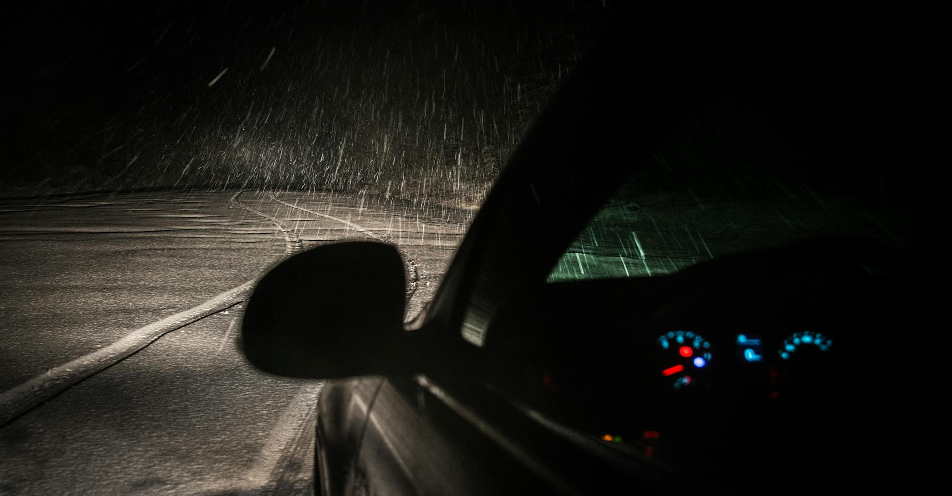 Ein Auto auf einer leeren Straße in einer regnerischen Nacht | Quelle: Pexels