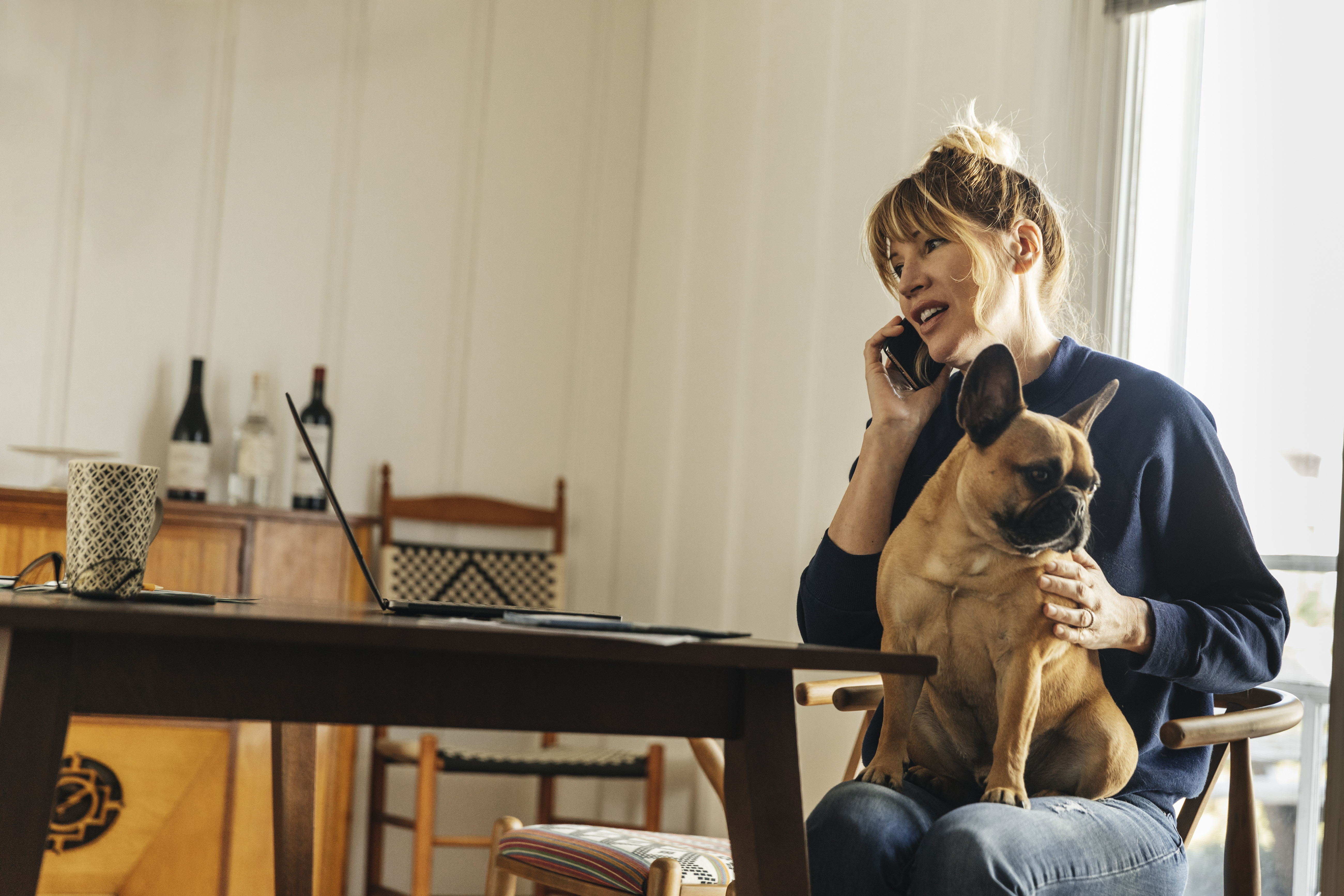 Frau arbeitet zu Hause mit Hund | Quelle: Getty Images