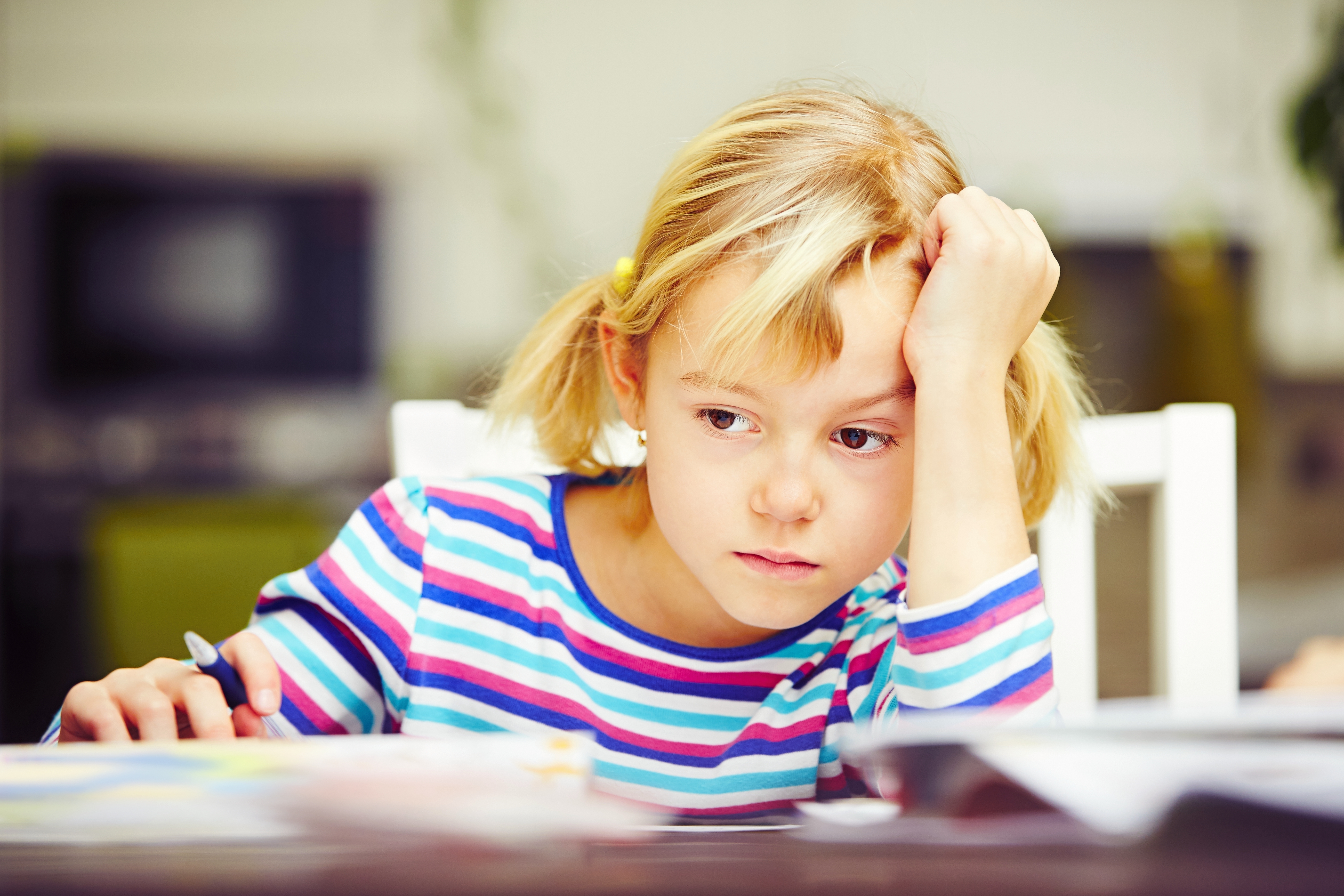 Kleines Mädchen schmollt an ihrem Schreibtisch | Quelle: Shutterstock