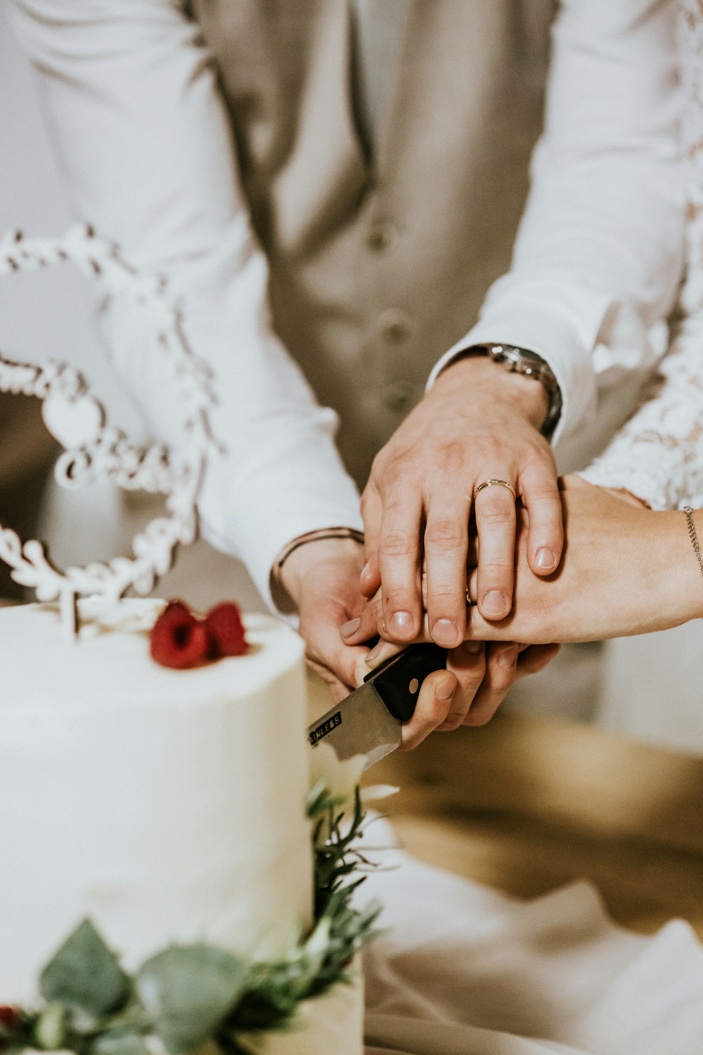 Ein Paar schneidet eine Hochzeitstorte an | Quelle: Unsplash