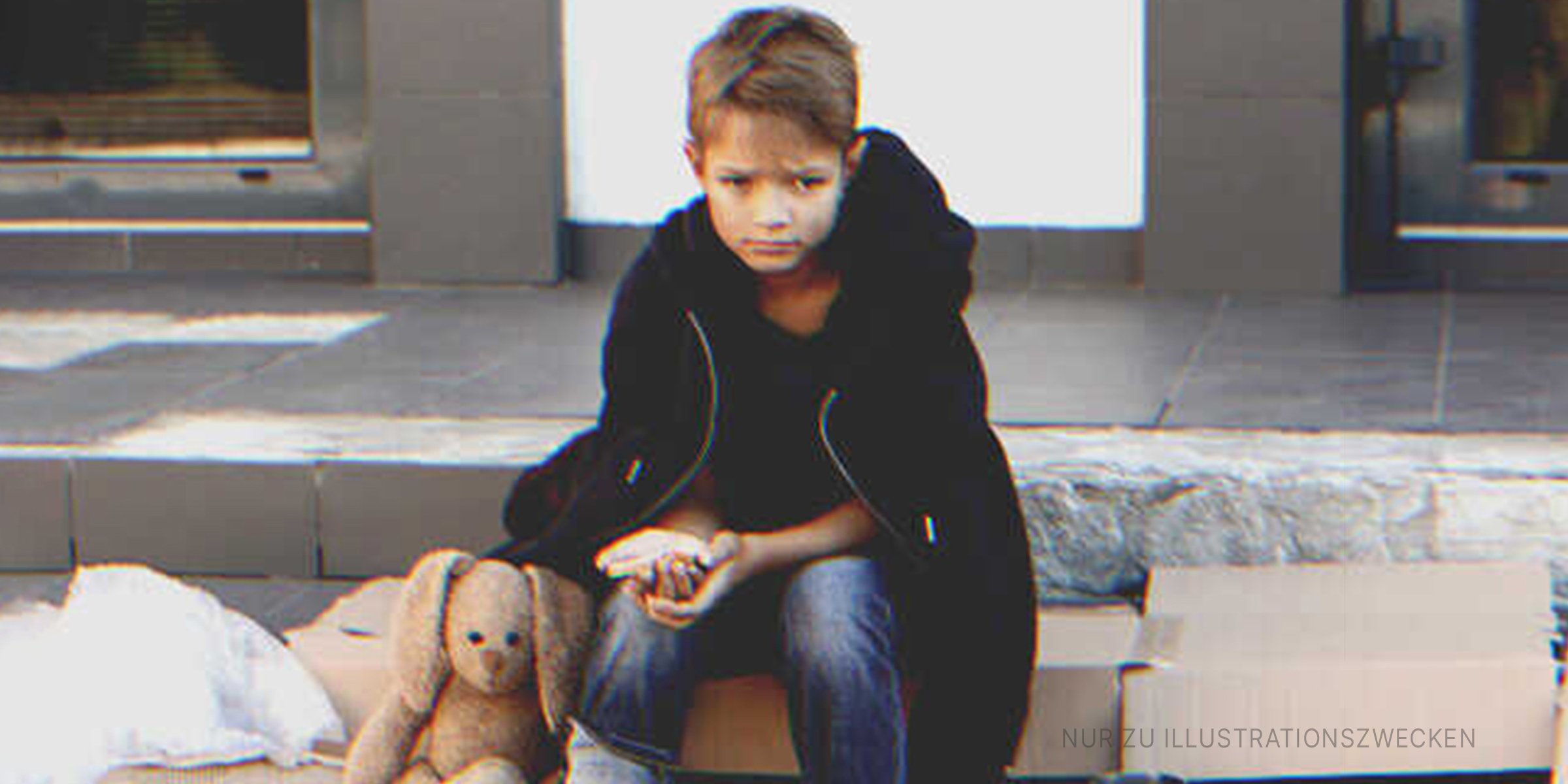 Trauriger Junge, der auf der Straße sitzt | Quelle: Shutterstock